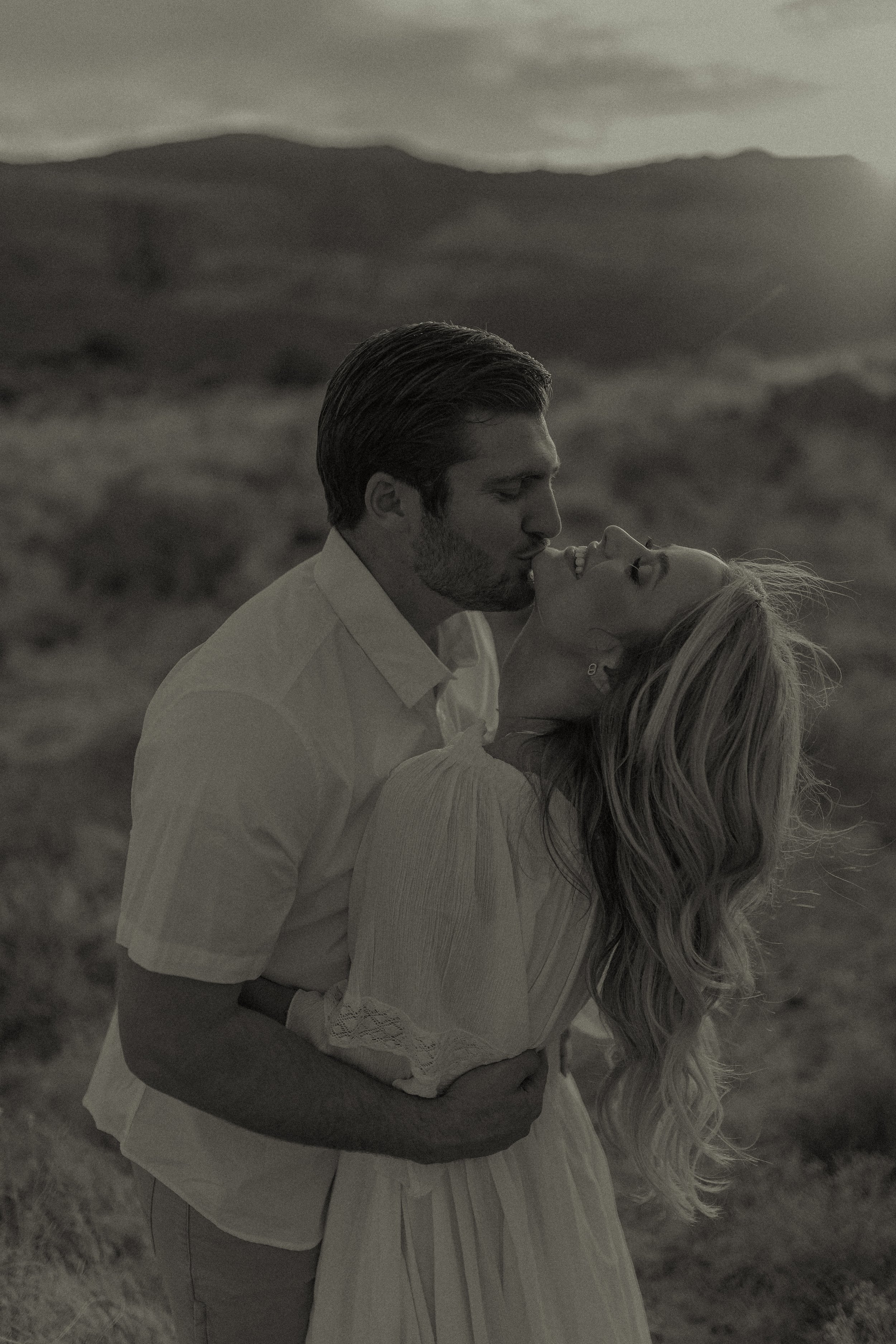 Couple embracing outdoors with mountains in background