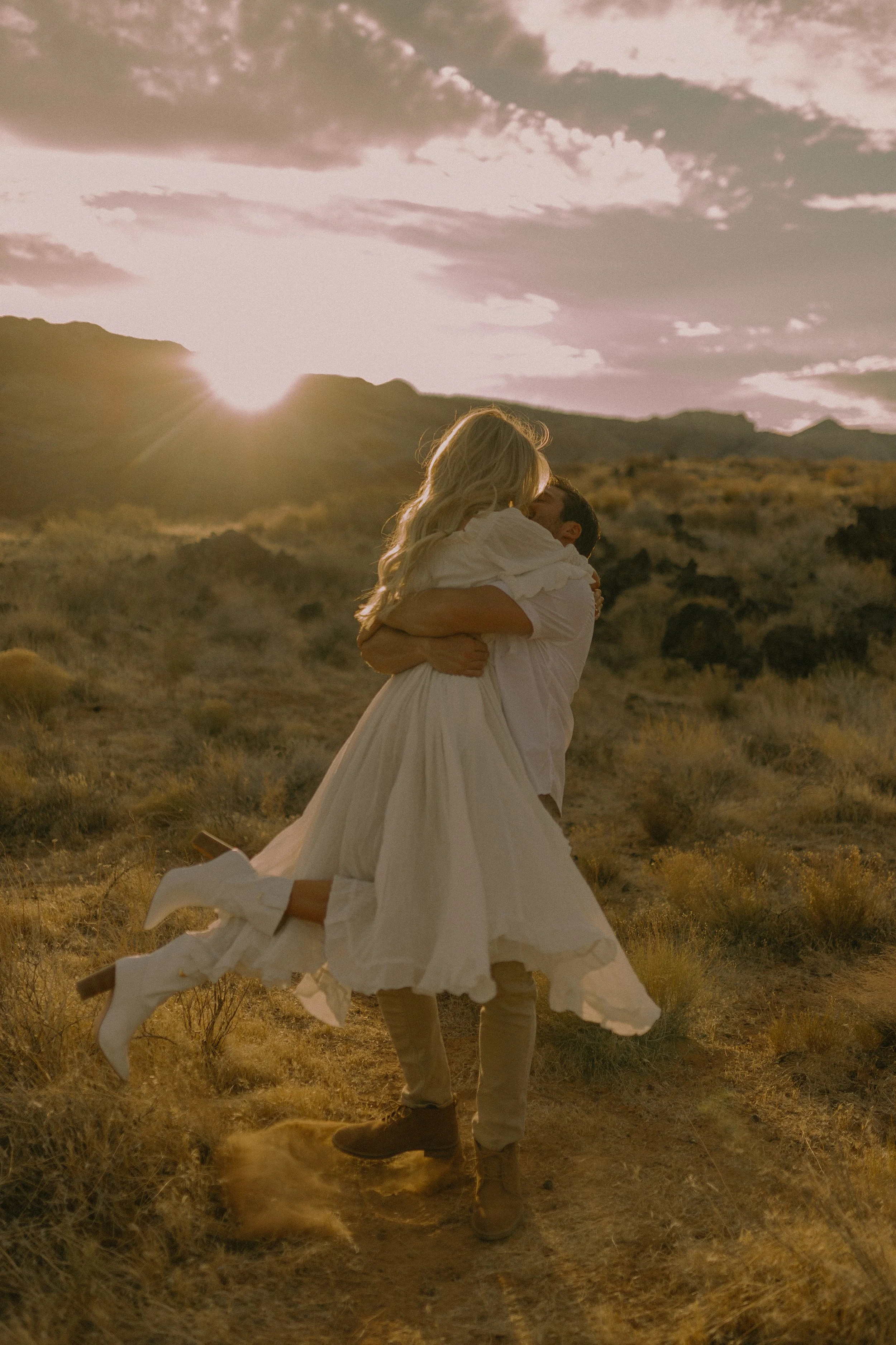 Couple embracing in desert at sunset