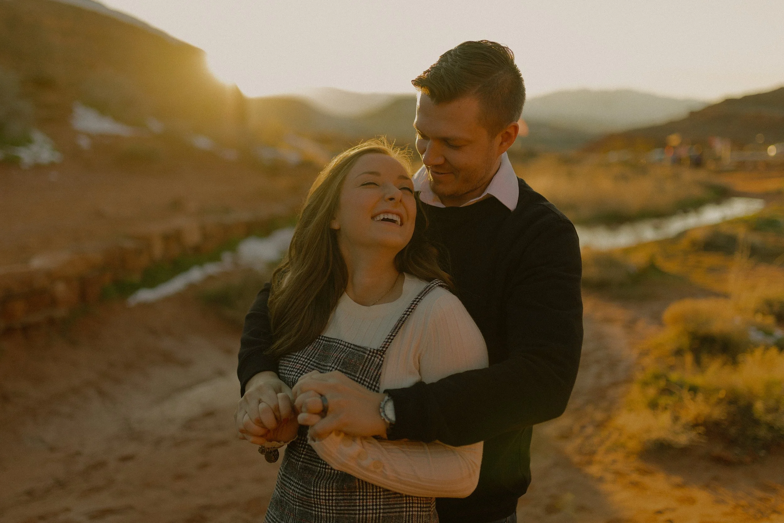 Couple embracing outdoors with sunset in the background