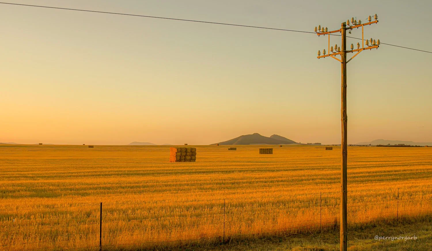Big rectangular stacks of hay bales at Golden Hour.