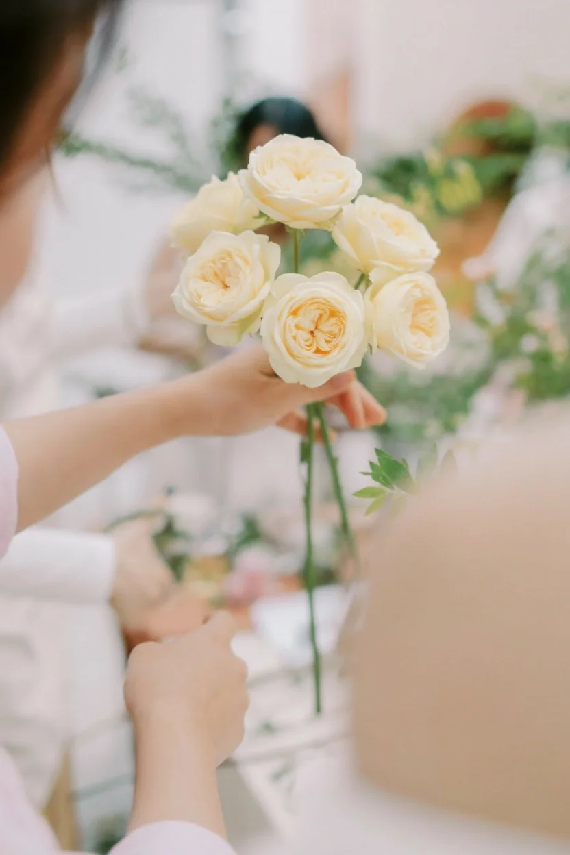 Osoba trzymająca bukiet jasno żółtych róż.