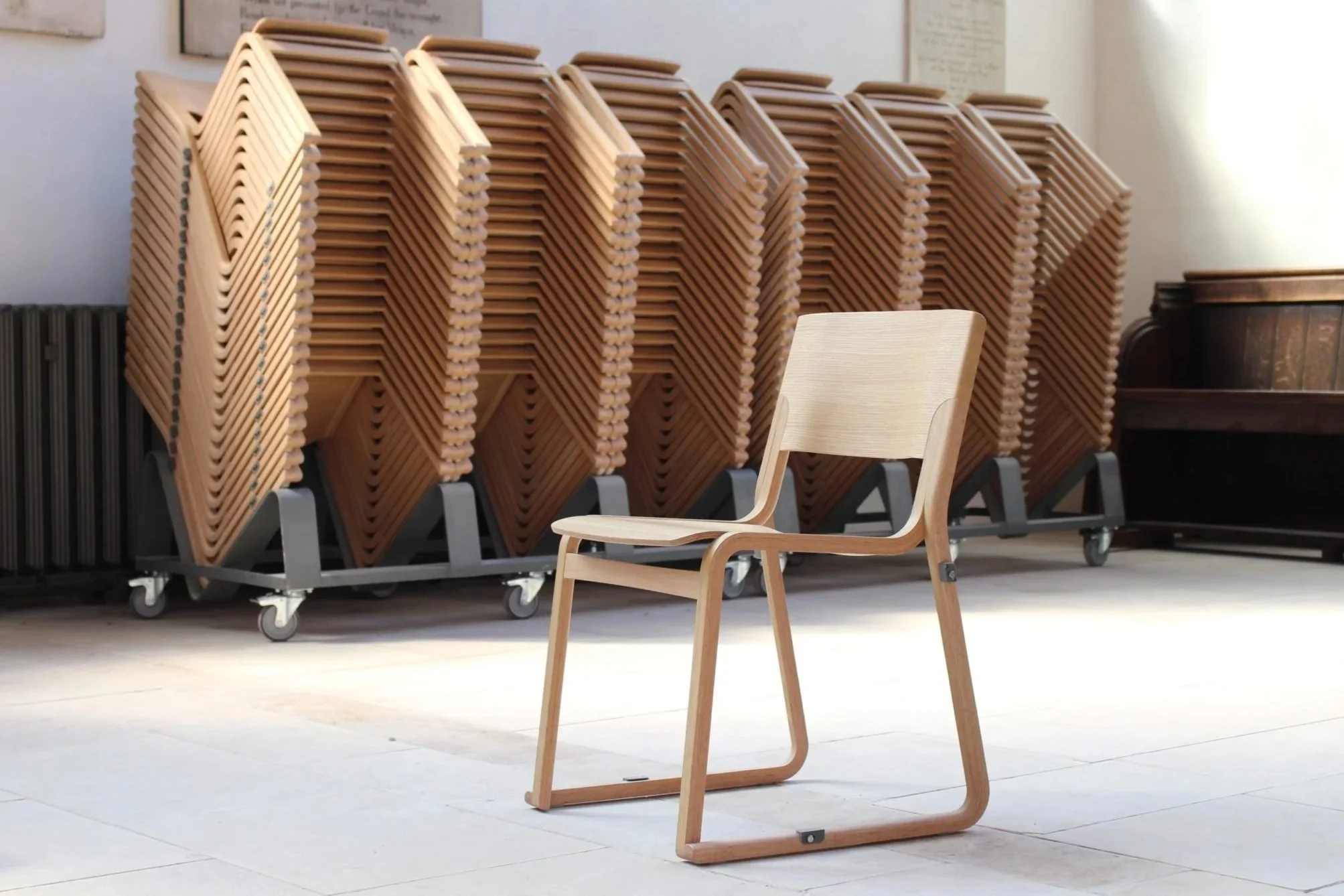 Theo – Stapel- und Verbindungsstuhl aus Holz, entworfen von Simon Pengelly. Hergestellt von New Design Group.