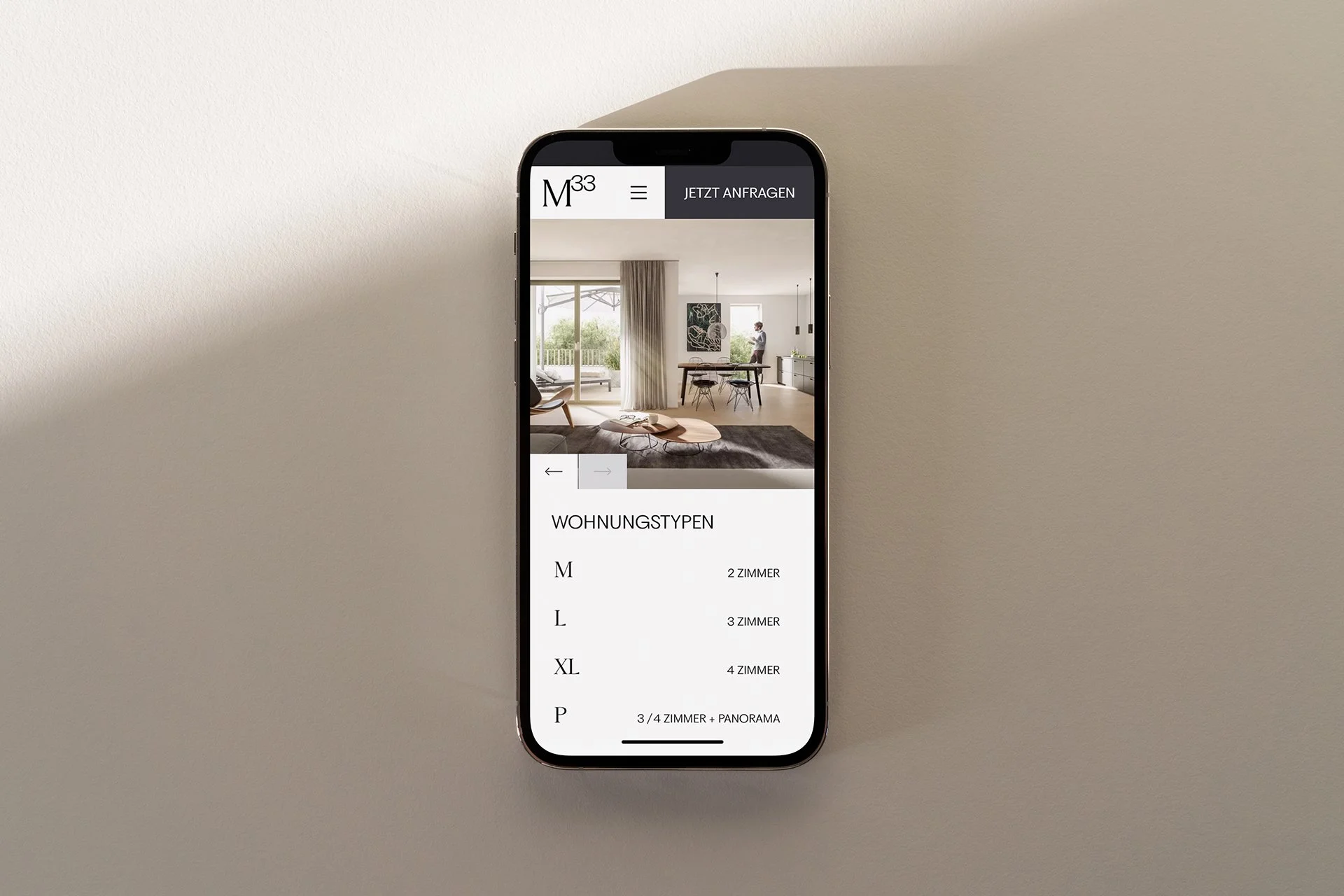 Smartphone zeigt eine Website mit Wohnungsangeboten, im Hintergrund beige Wand