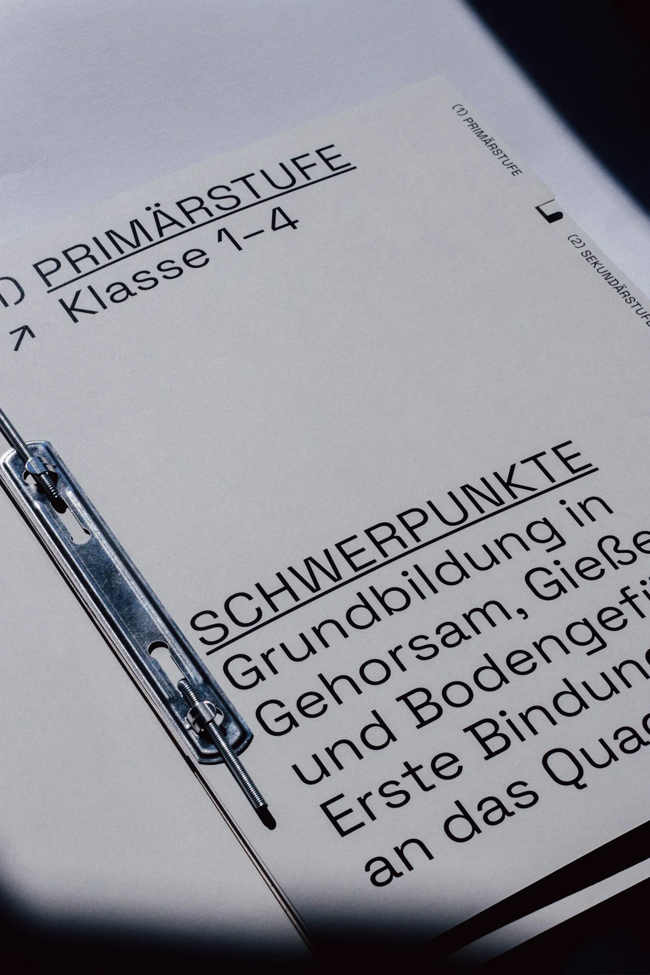 Schwarz-weiß-Kursbuch für Grundbildung in Gehörsam, Boden und Erste Hilfe an Grundschulen, mit Metallringheftung.