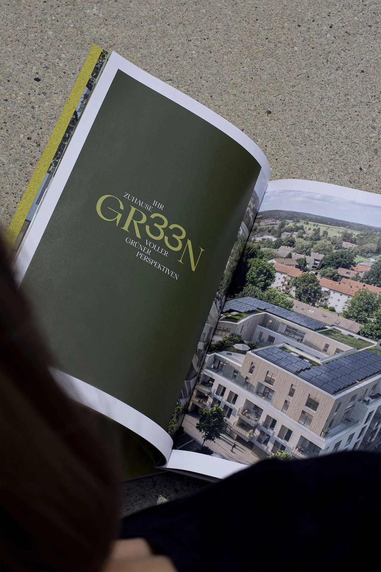 Offenblätter eines Architektur- oder Immobilienkatalogs mit einem Bild eines modernen Wohngebäudes in einer grünen Umgebung.