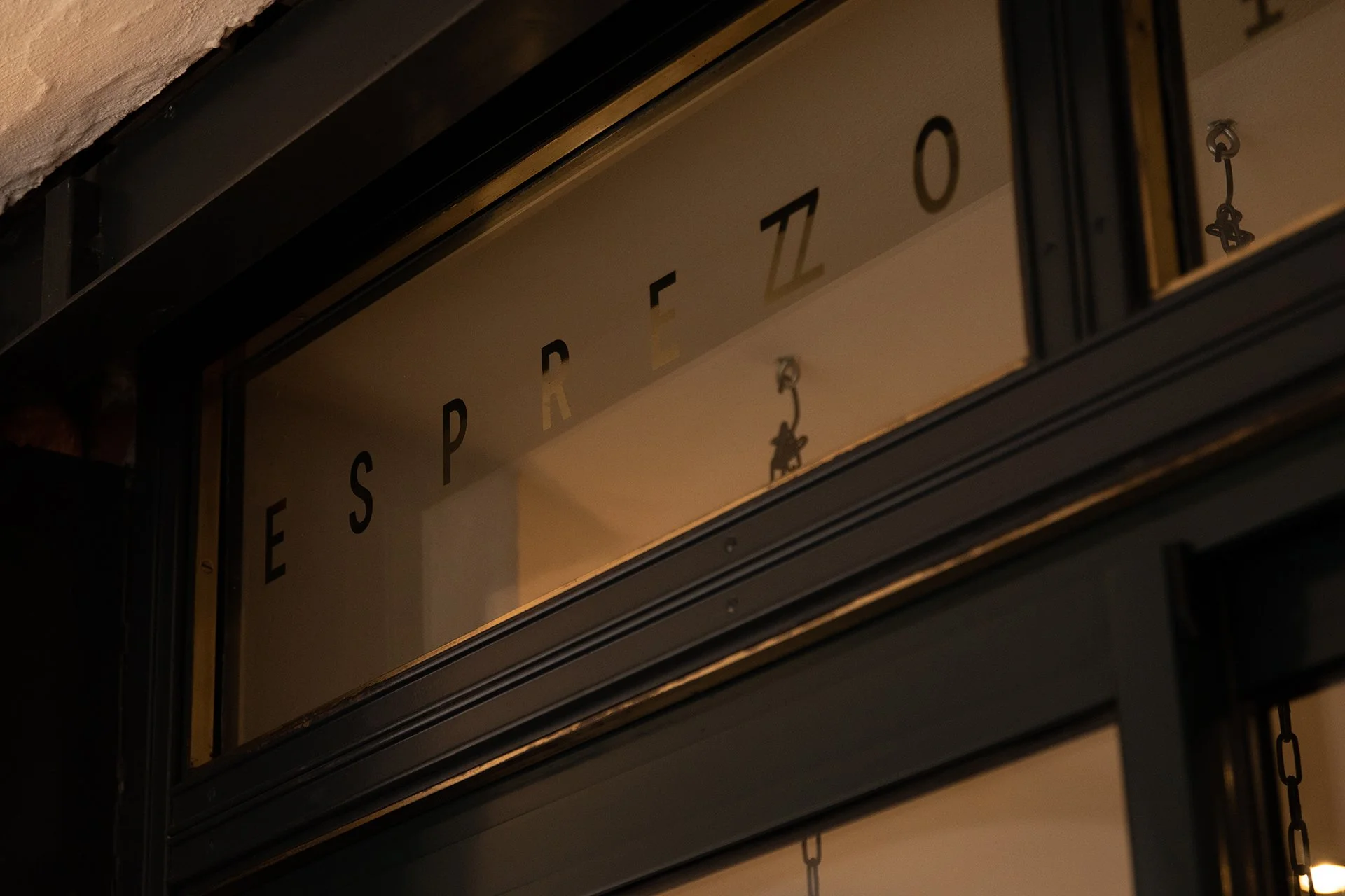 Ein Schaufenster mit alphabetischer Beschriftung und kleinen Figuren hinter Glas, nachts beleuchtet.