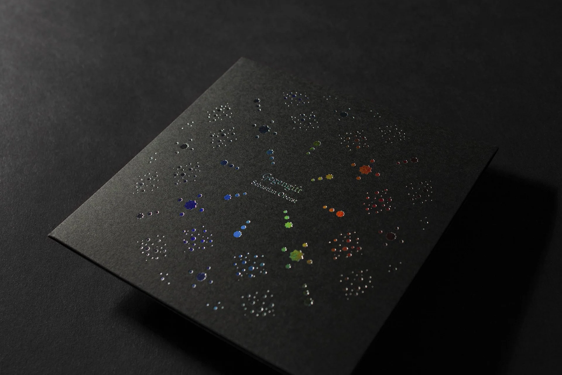 Irisierende CD-Hülle mit farbigen, glitzernden Sternenmustern und dem Titel 'Gegengift' von Sebastian Oberst.