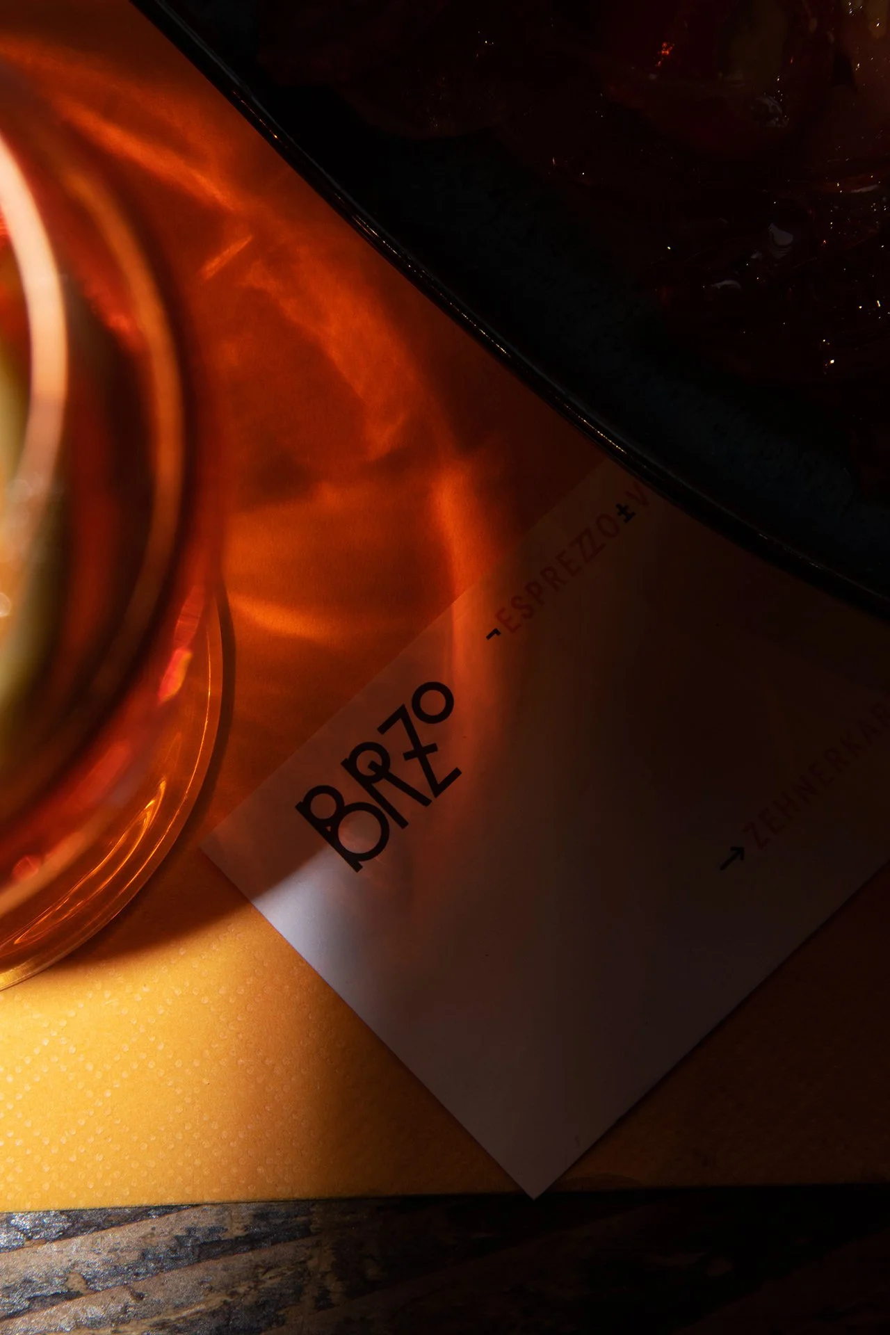 Nahaufnahme eines Tisches mit einem Glas mit orangefarbener Flüssigkeit, einem Messer und einer Zeitschrift auf einem orangefarbenen Tisch.