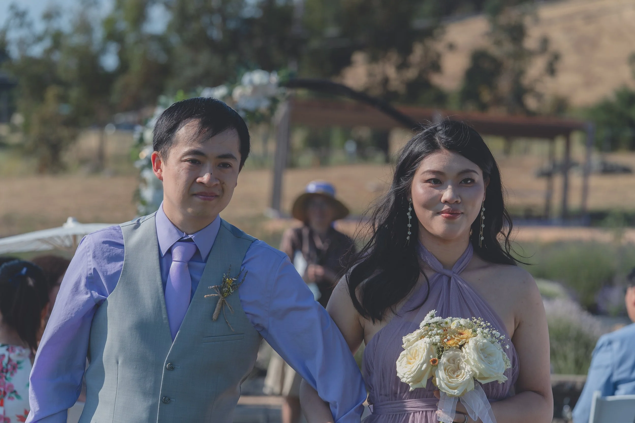 Newlyweds smiling together with their bouquet after the ceremony in Sonoma.