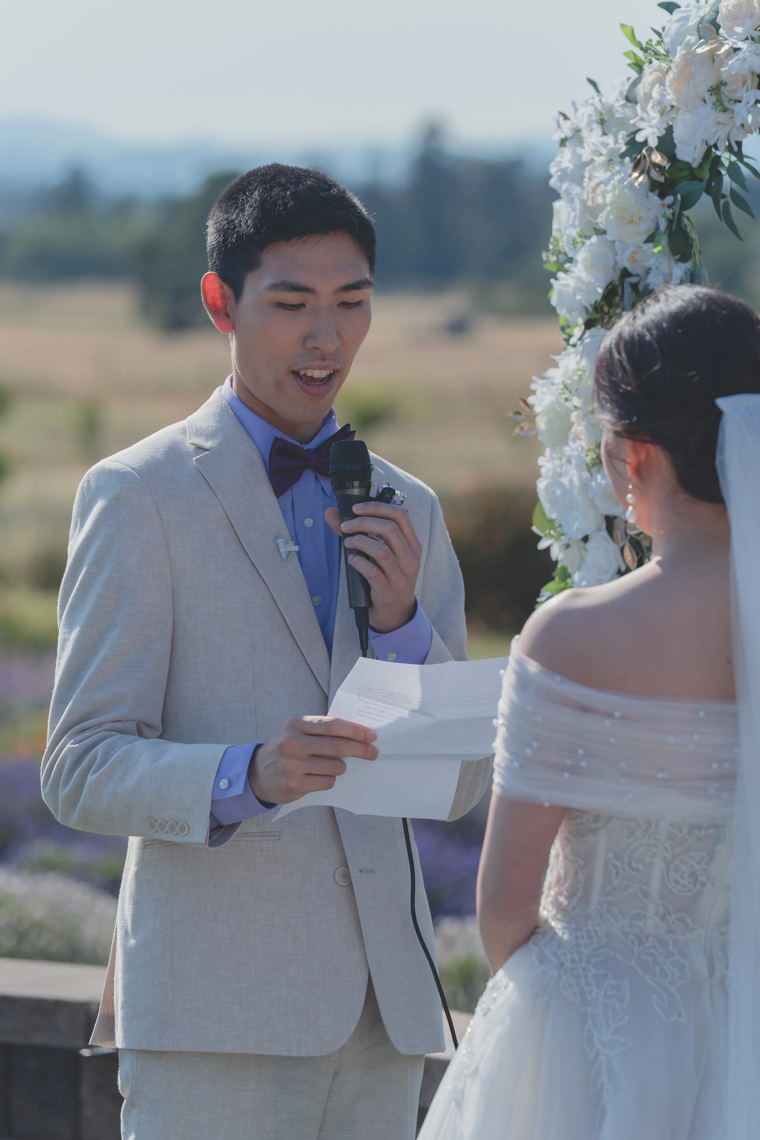 Groom holding the microphone while sharing vows at Katherine and Calvin’s Sonoma wedding.