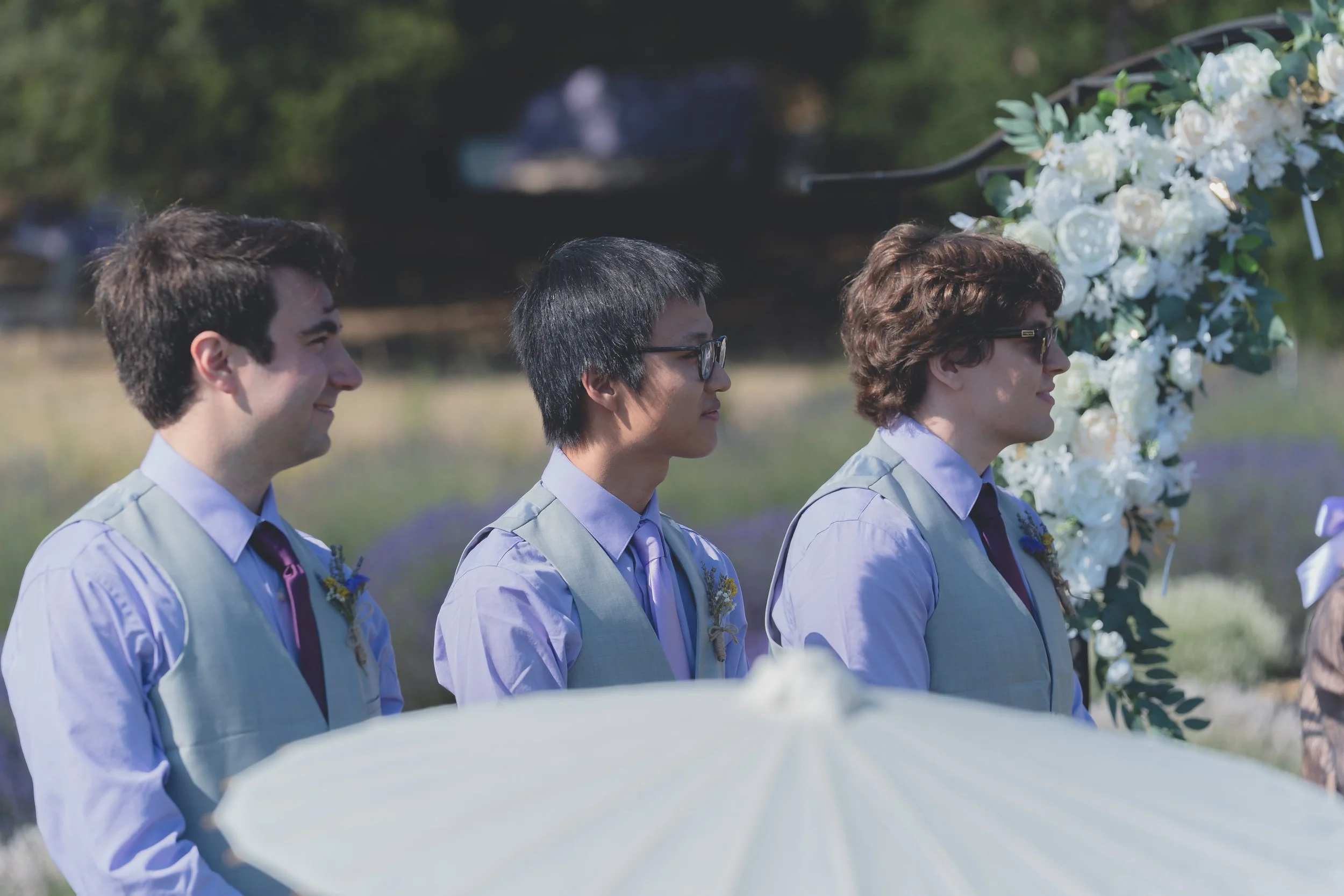 Groomsmen standing together near the ceremony space at a Sonoma wedding.