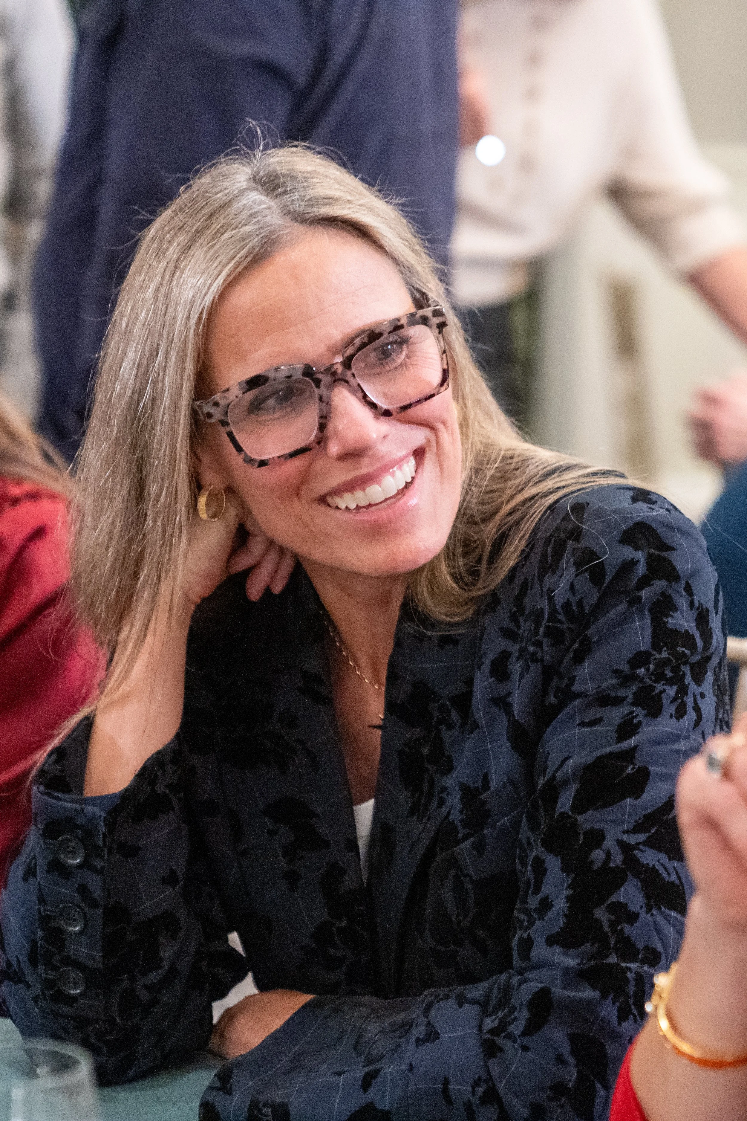 Smiling woman with glasses at a social event