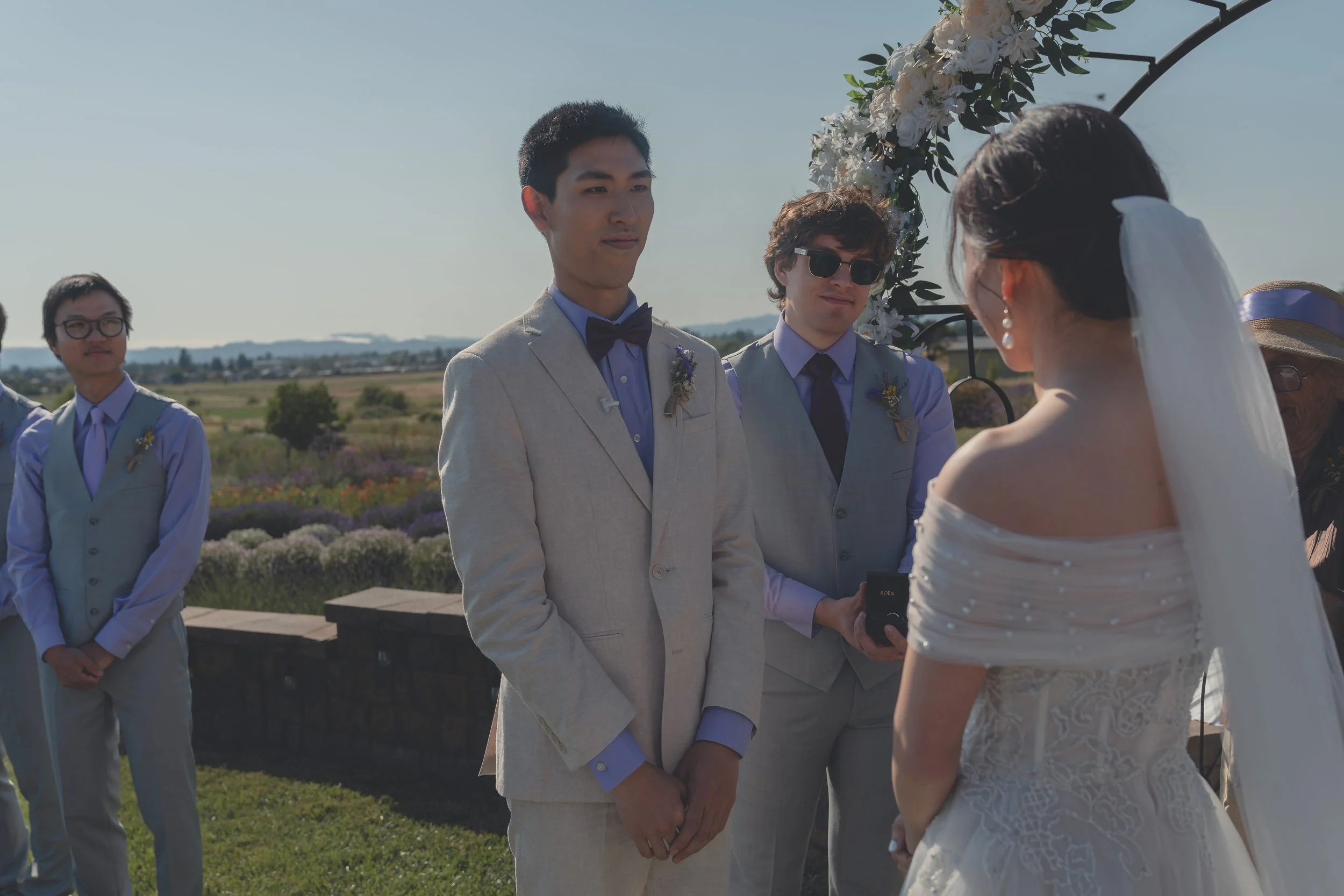 Bride and groom facing one another beneath the ceremony arch in Sonoma.