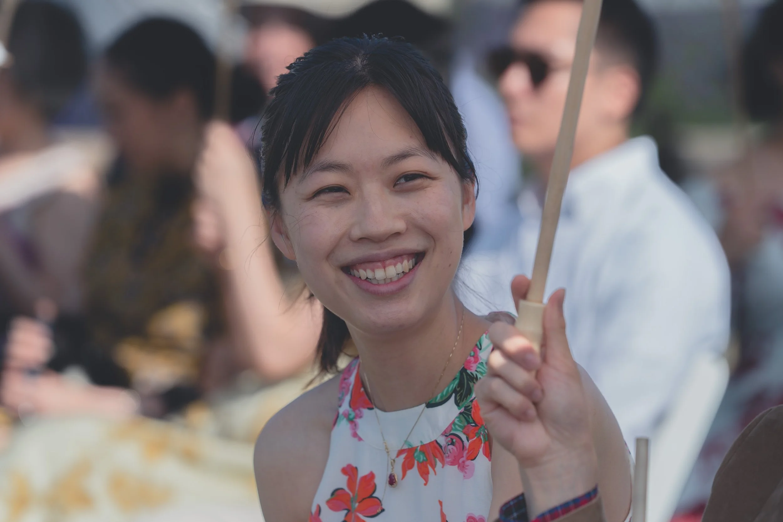 Guest smiling and holding a wedding program during the Sonoma ceremony.