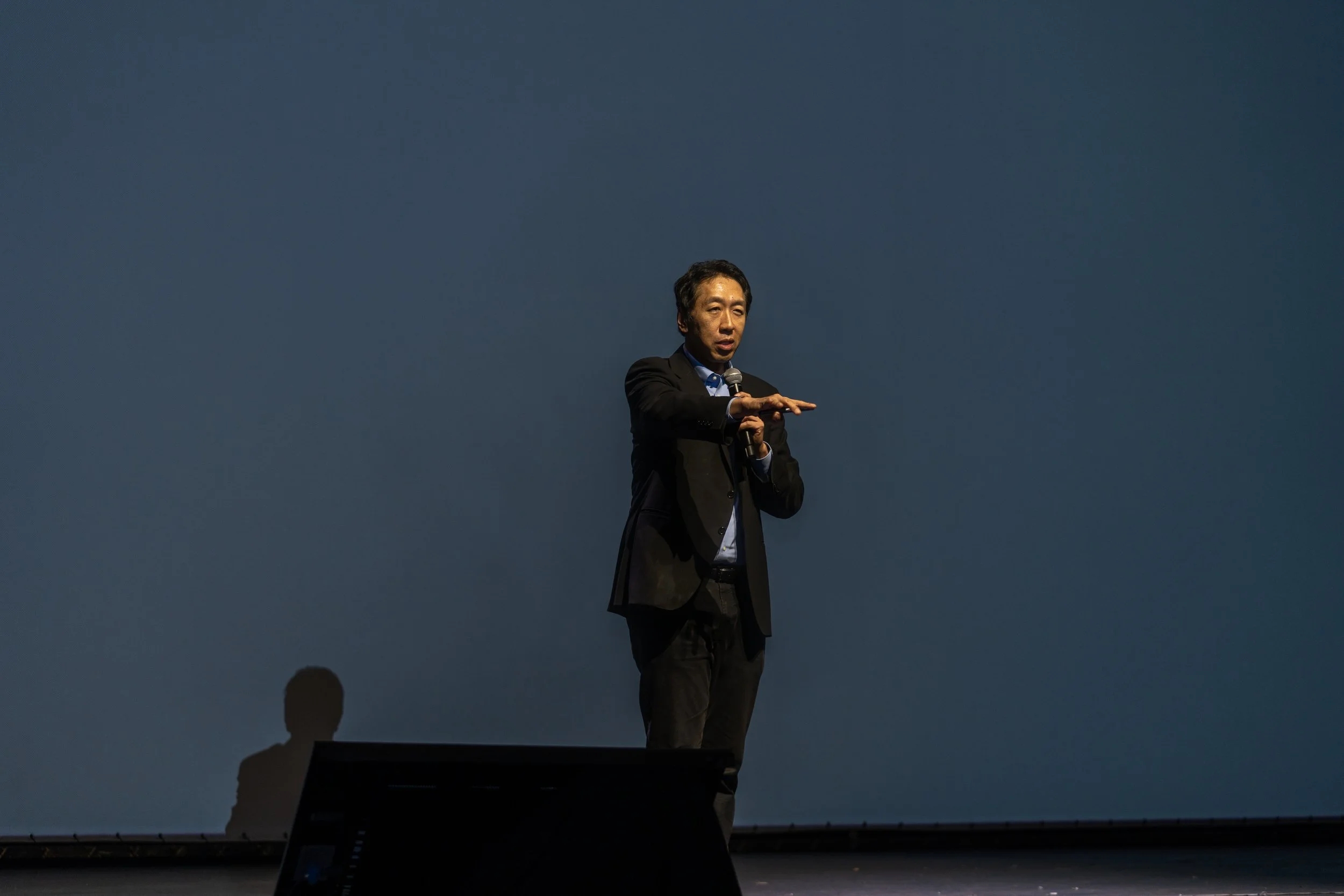 Speaker on stage with microphone and blue background