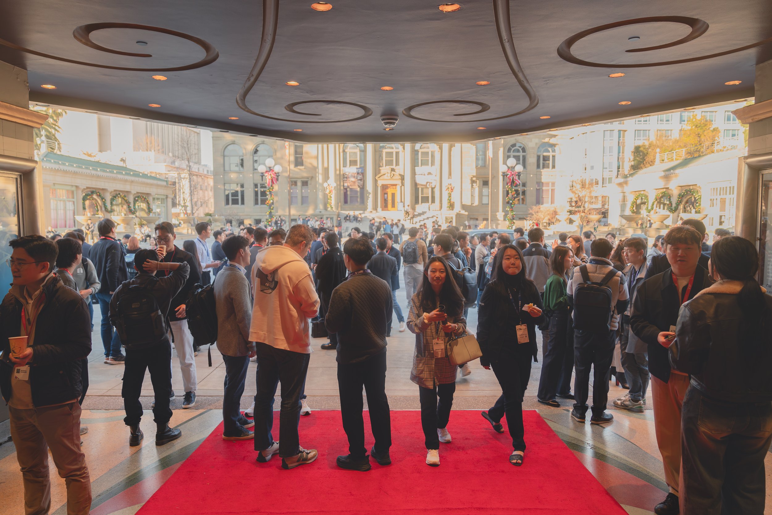 Group of people gathered on a red carpet entrance