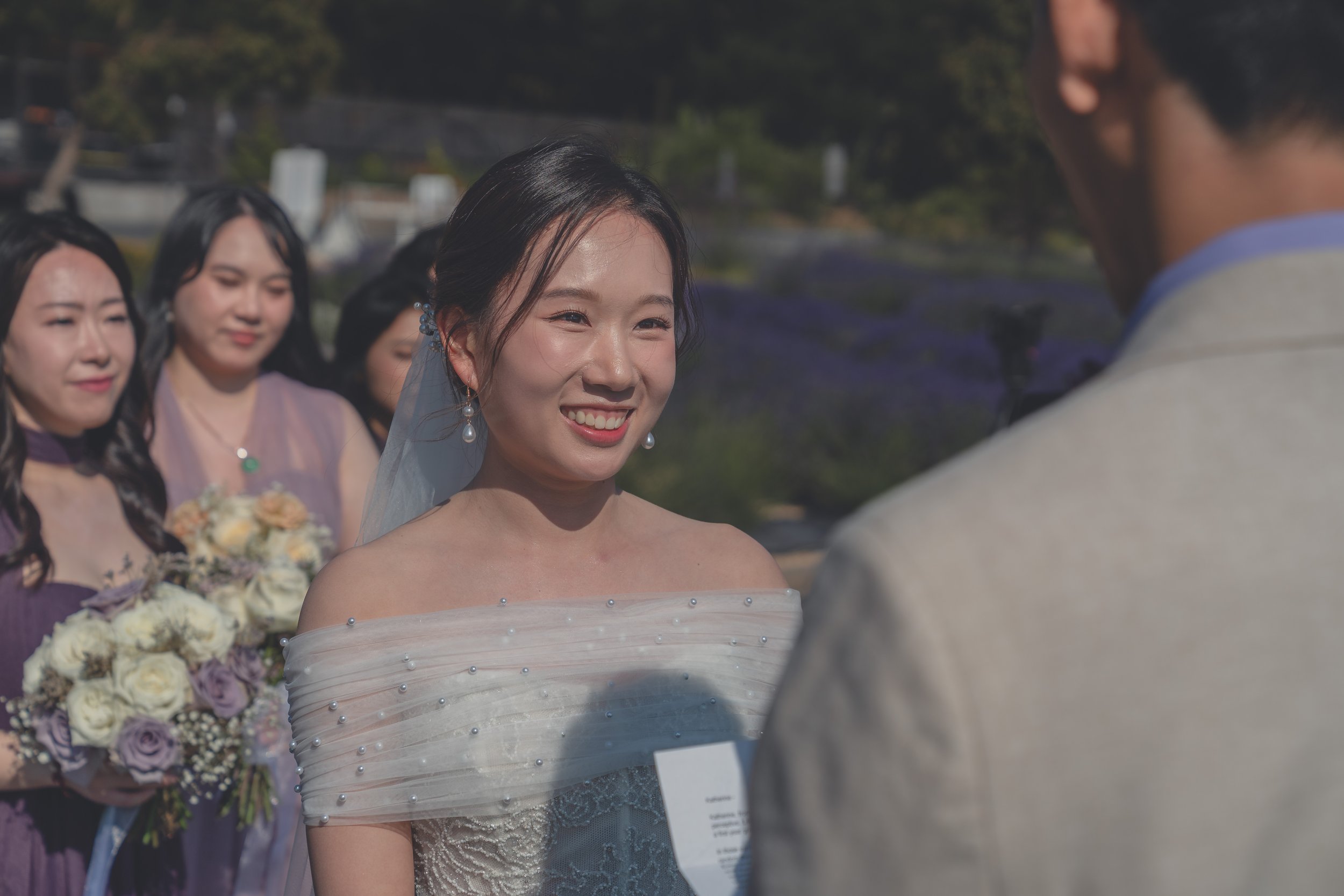 Bridesmaids smiling and reacting during Katherine and Calvin’s Sonoma wedding ceremony.