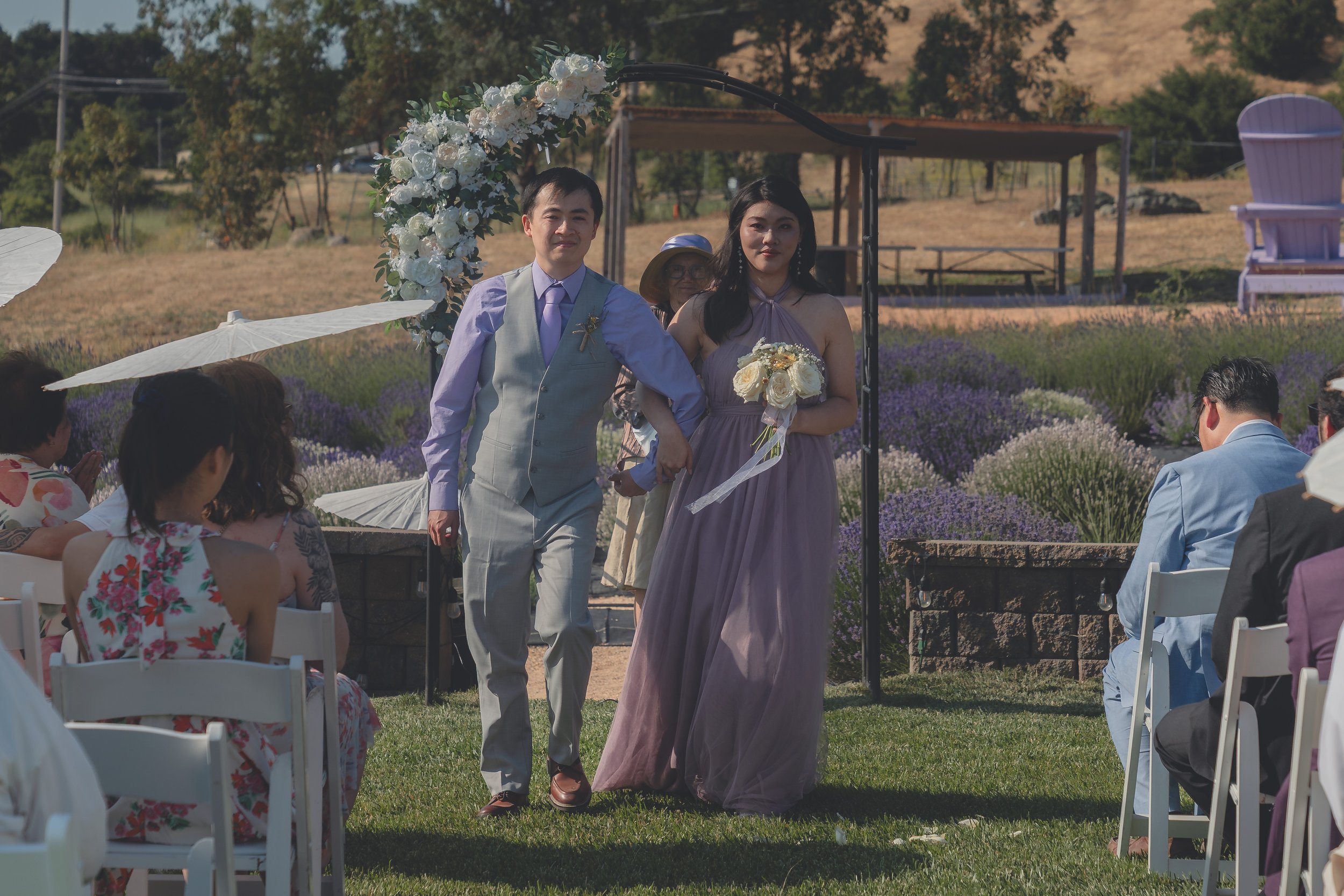 Bride and groom walking together through the venue grounds after the ceremony in Sonoma.