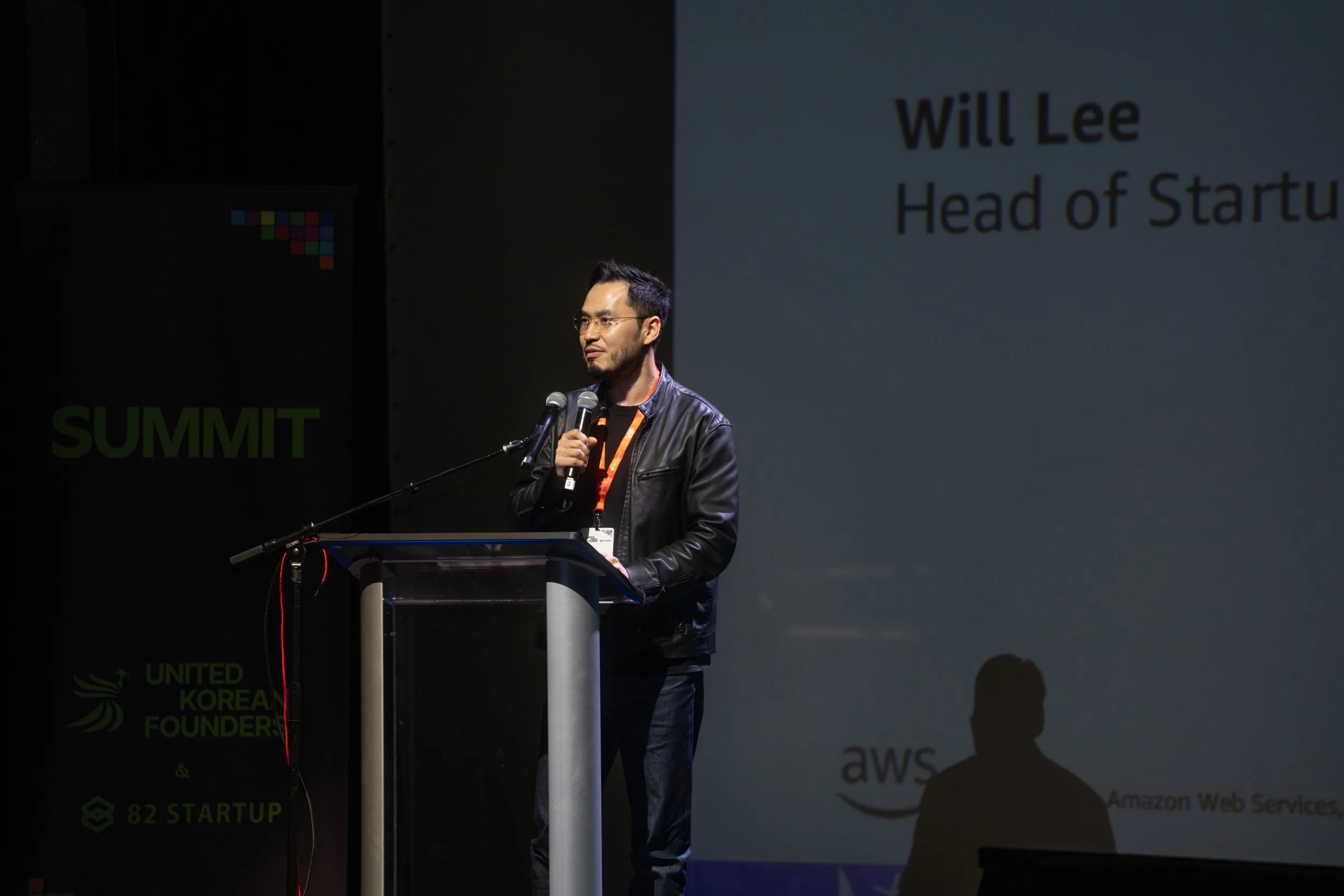 A person speaking at a podium during a summit event.