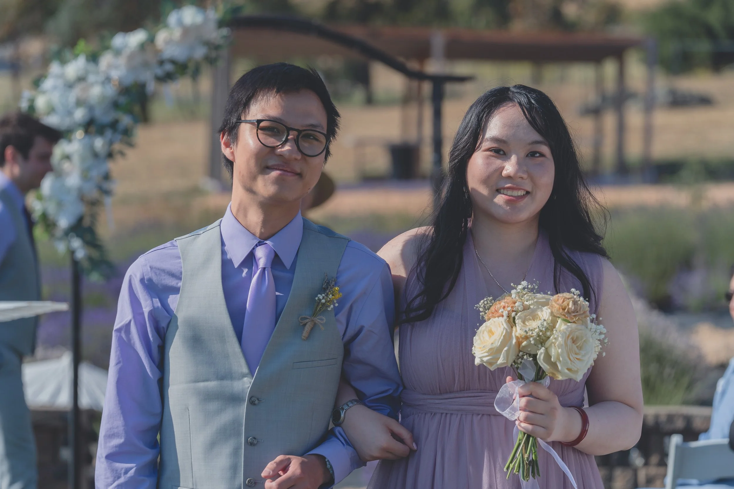 Bride and groom smiling together as guests gather around them in Sonoma.