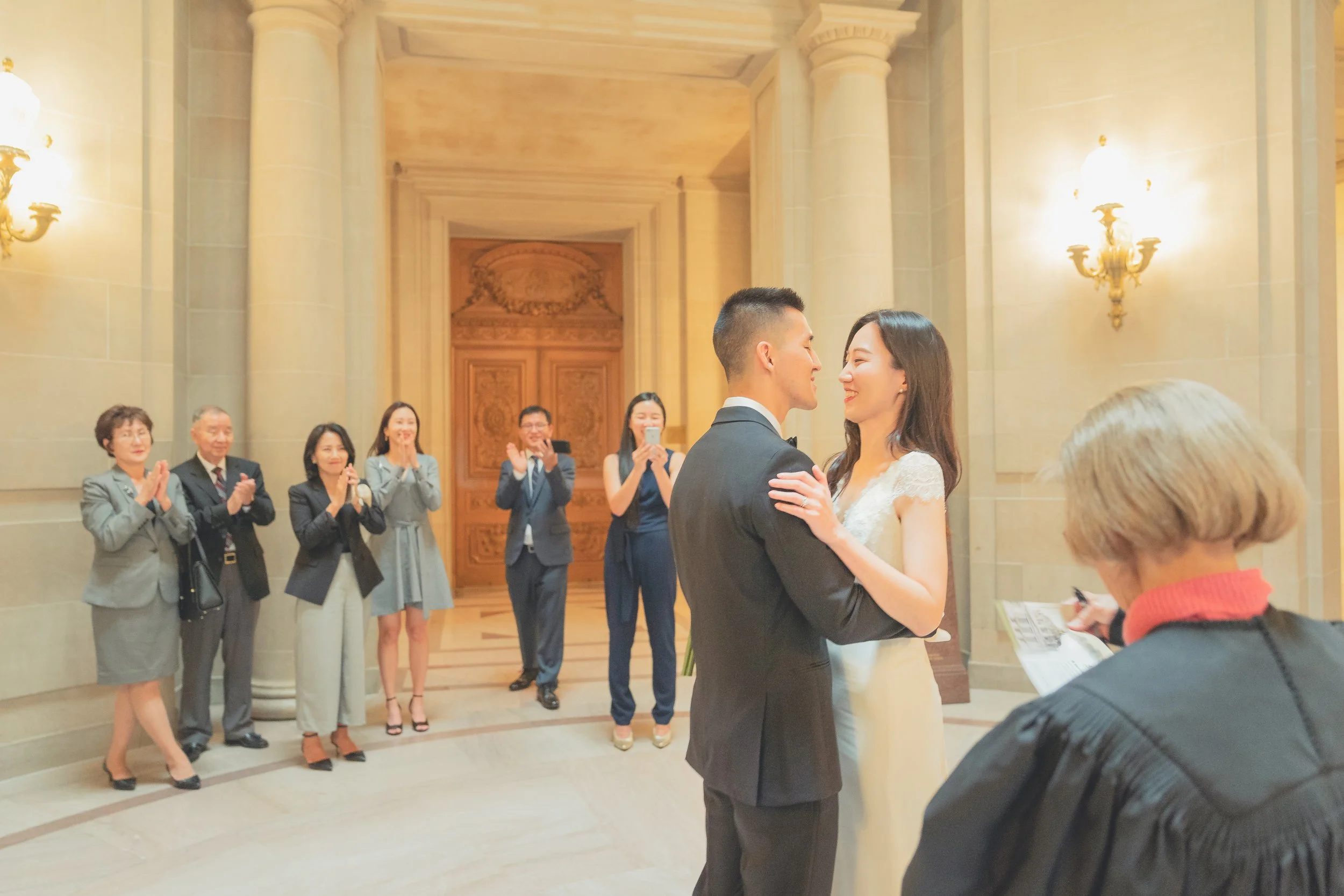 Emotional moment during a San Francisco City Hall wedding ceremony surrounded by close family and friends.