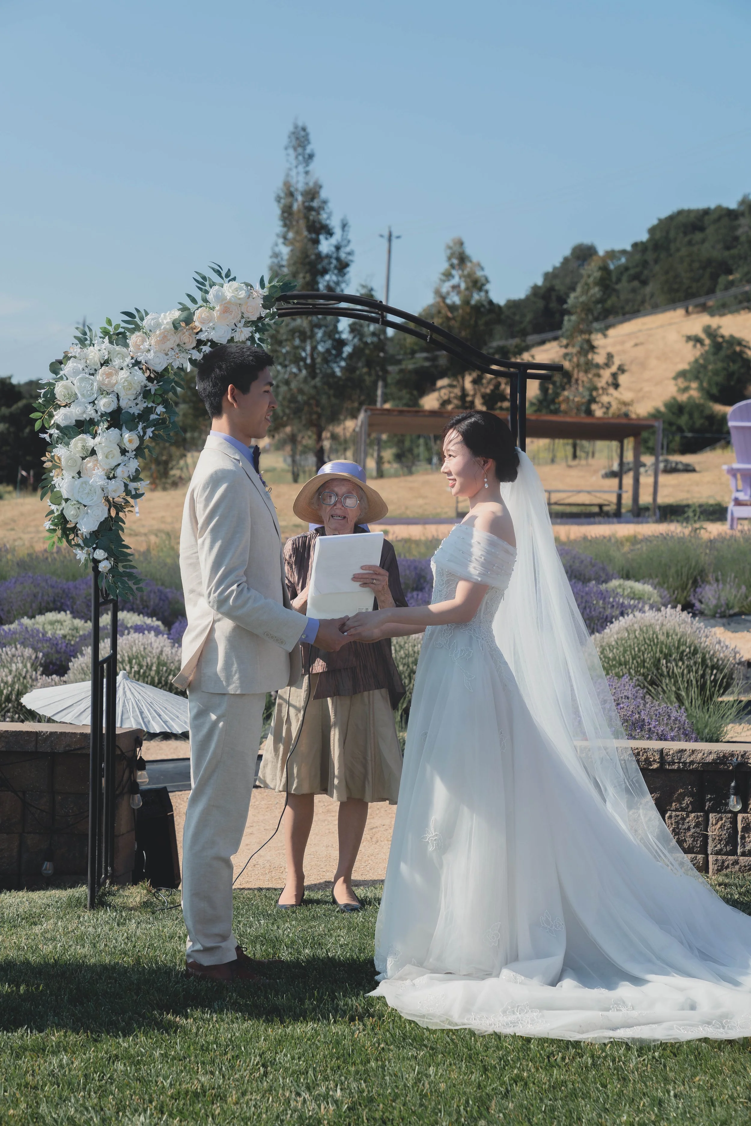 Bride and groom standing beneath the ceremony arch during their Sonoma wedding.
