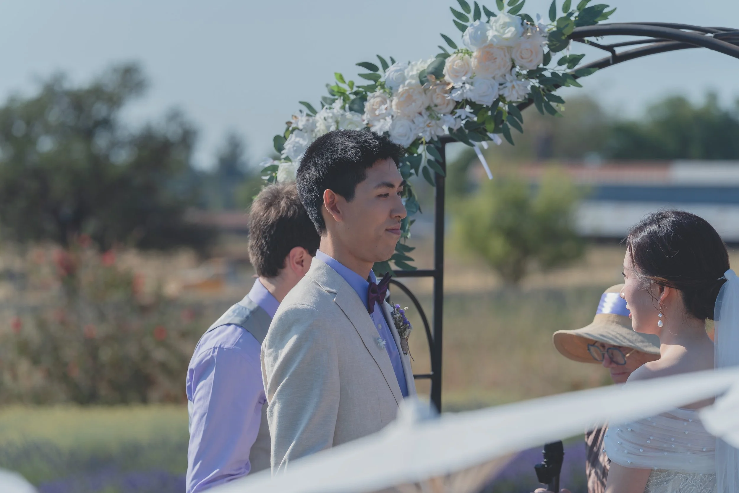 Bride and groom sharing a quiet moment beneath the ceremony arch in Sonoma.