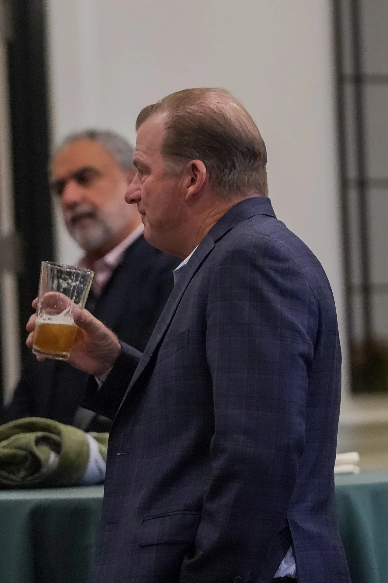 Man in suit with beer at gathering