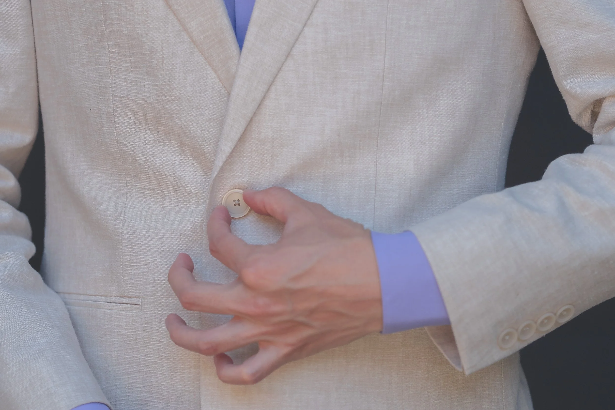 Groom hands and attire detail captured with a refined, documentary approach.
