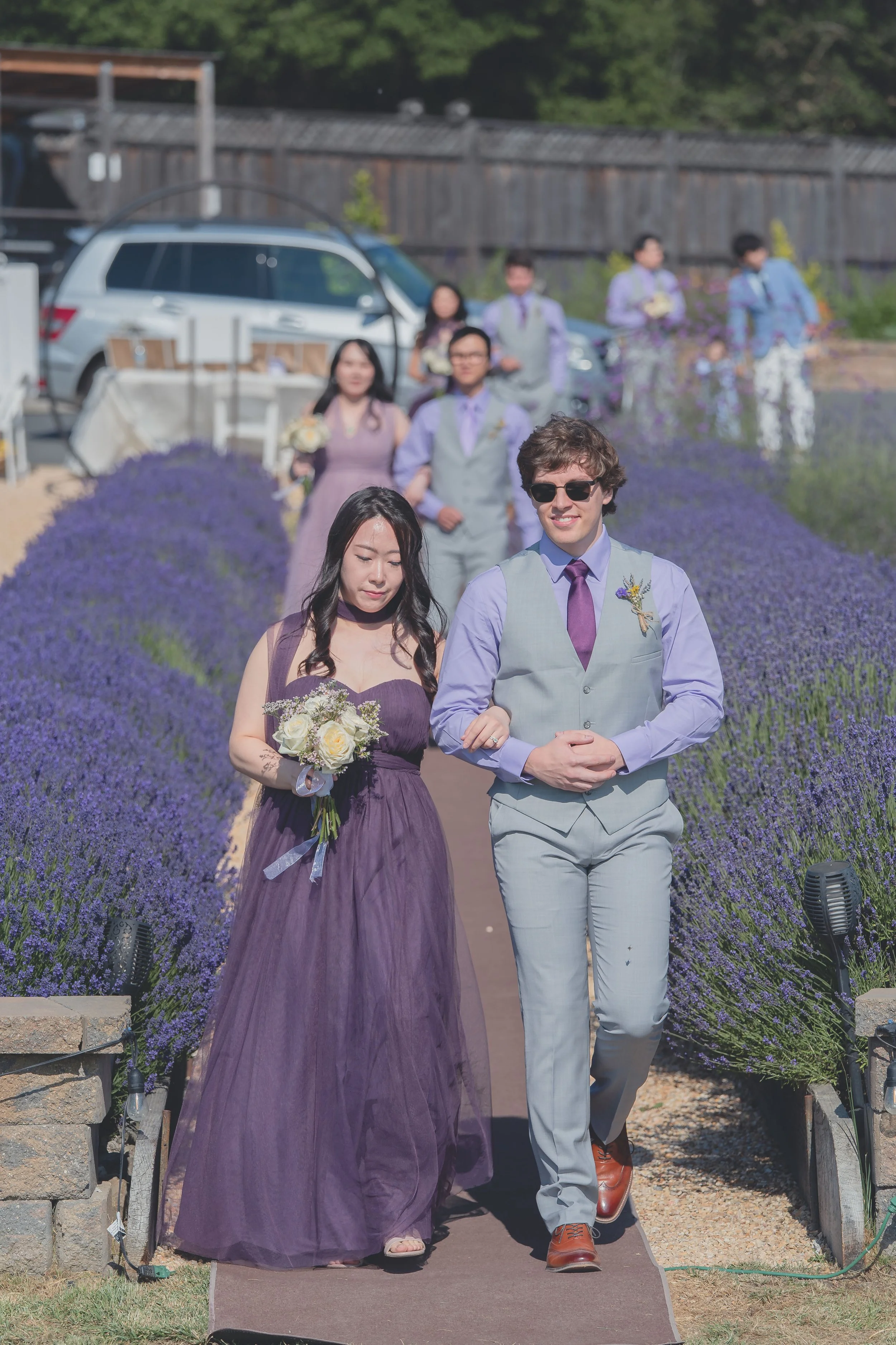 Groom standing with family members during the ceremony procession in Sonoma.