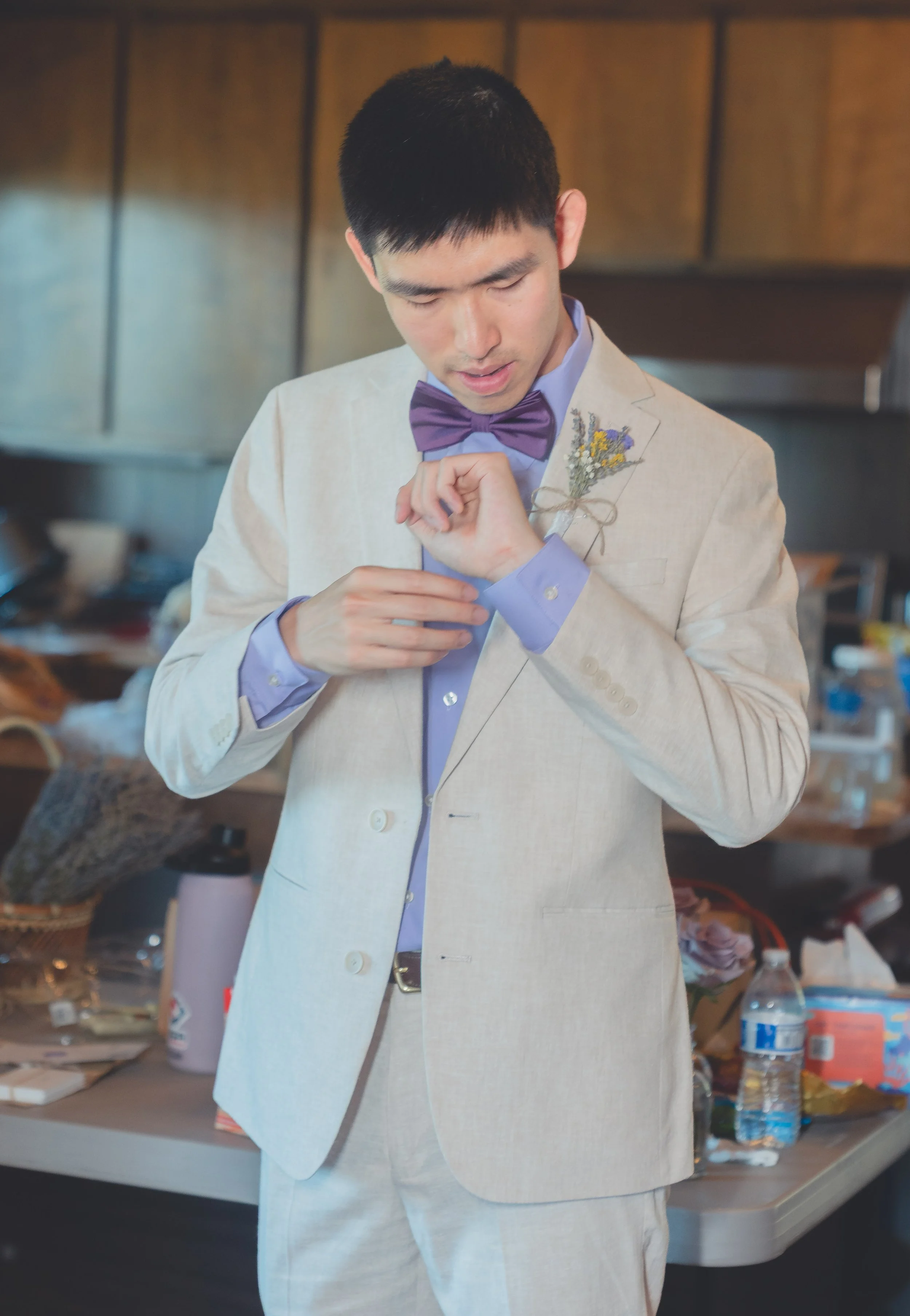 Groom adjusting attire during wedding preparations in Sonoma.