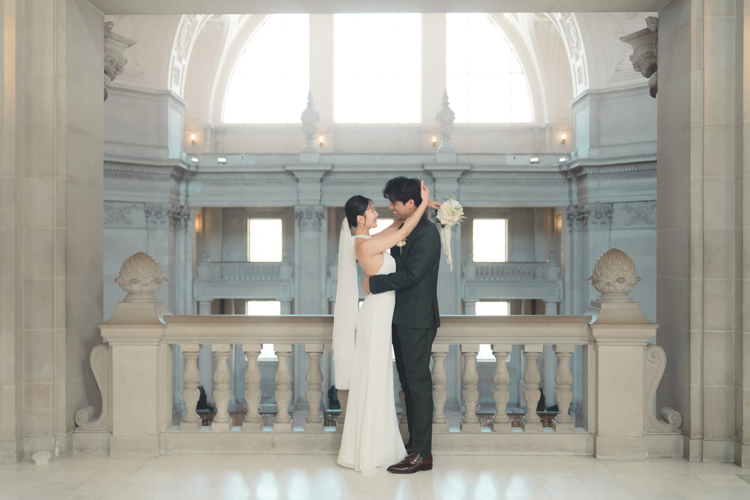 Bride and groom embracing inside San Francisco City Hall after their civil wedding ceremony.