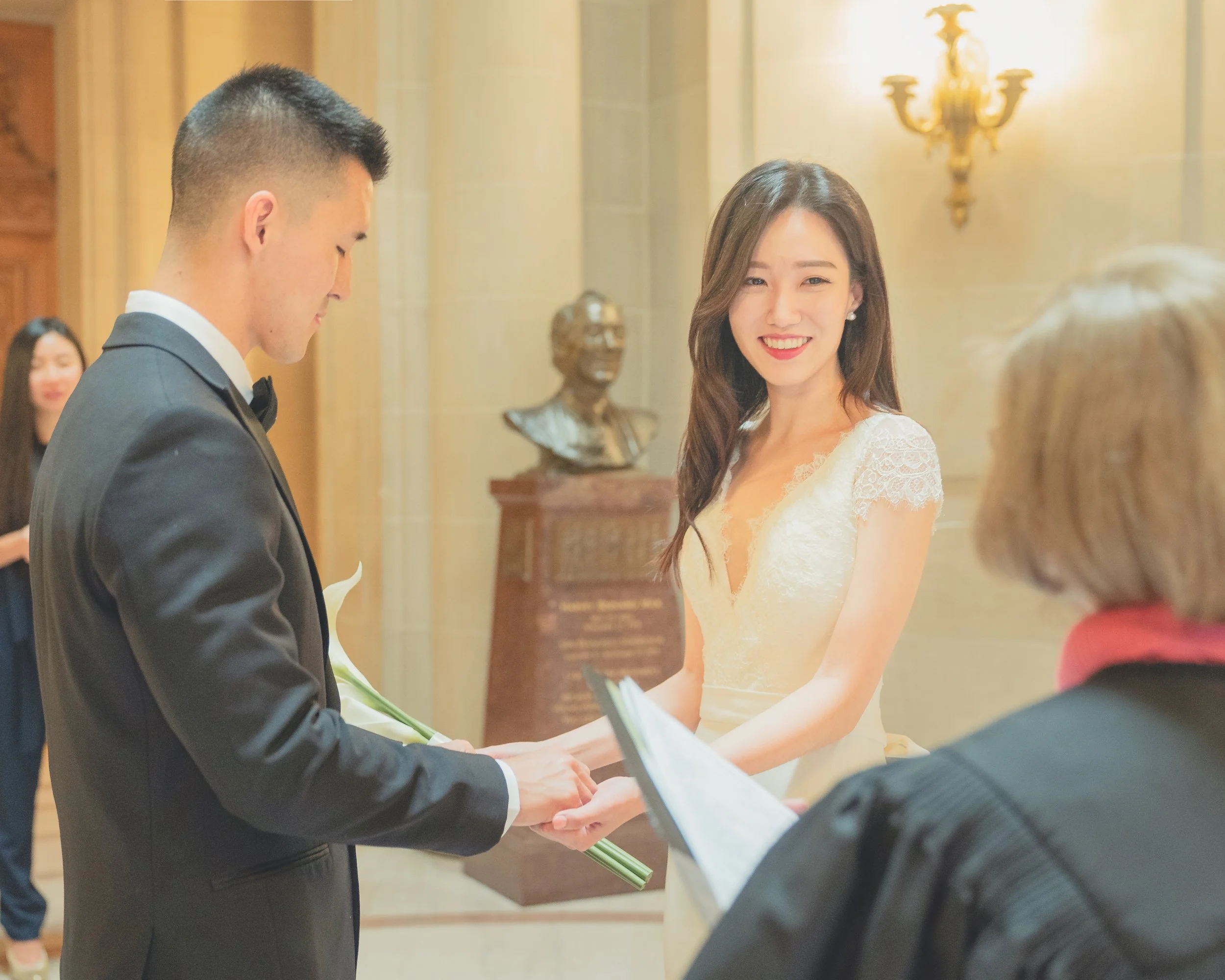 Bride and groom exchanging rings during a San Francisco City Hall civil ceremony.