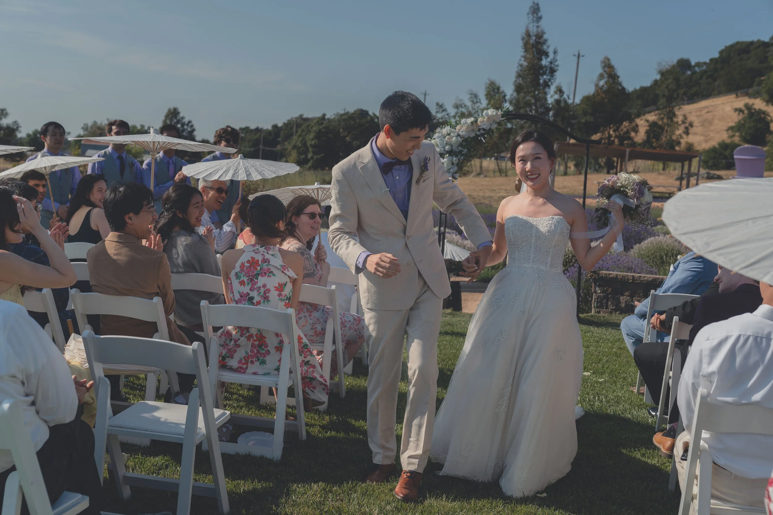 Guests applauding as Katherine and Calvin walk down the aisle after the ceremony.