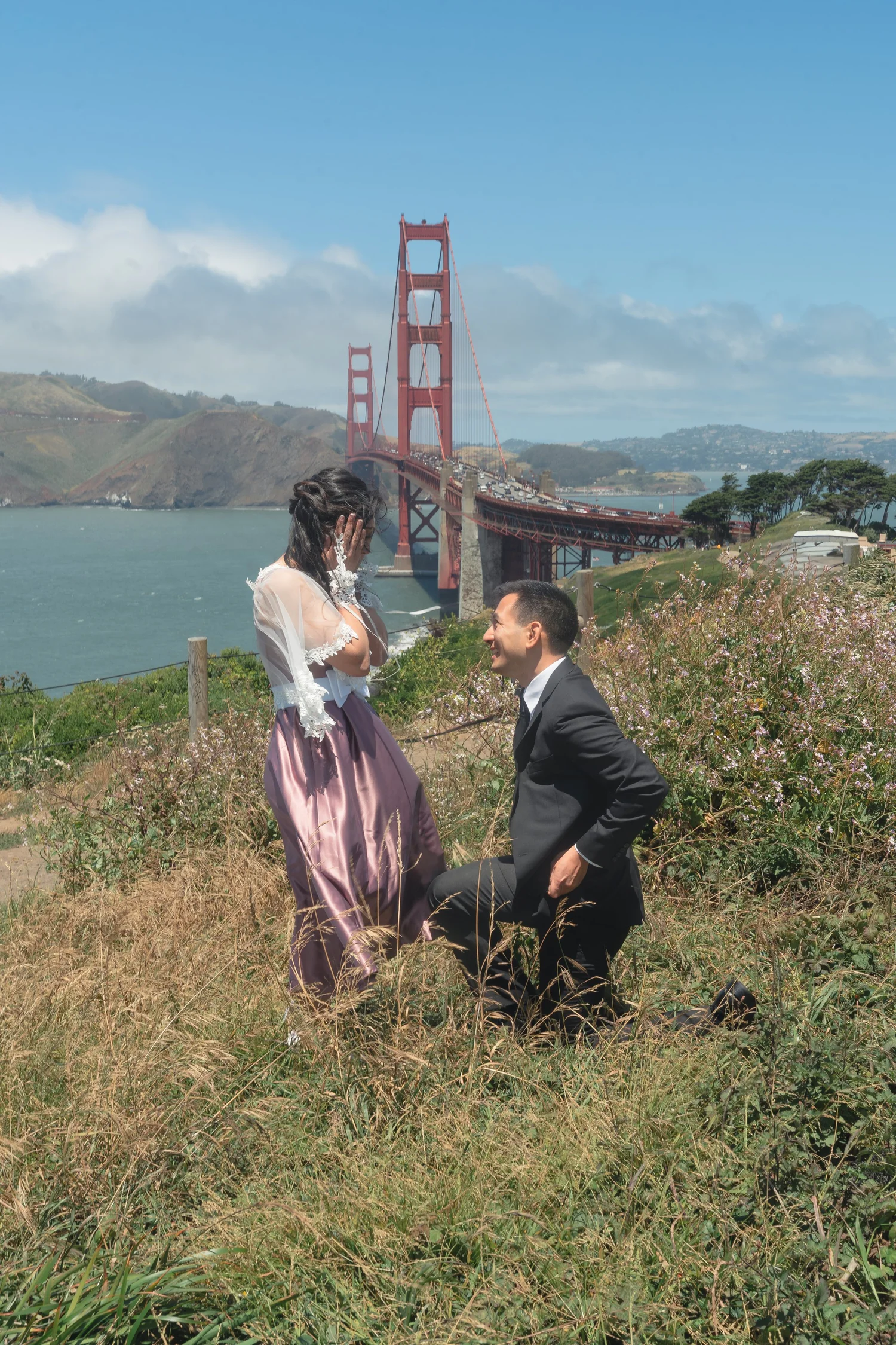 Sam on one knee, Phorum's hands to her face