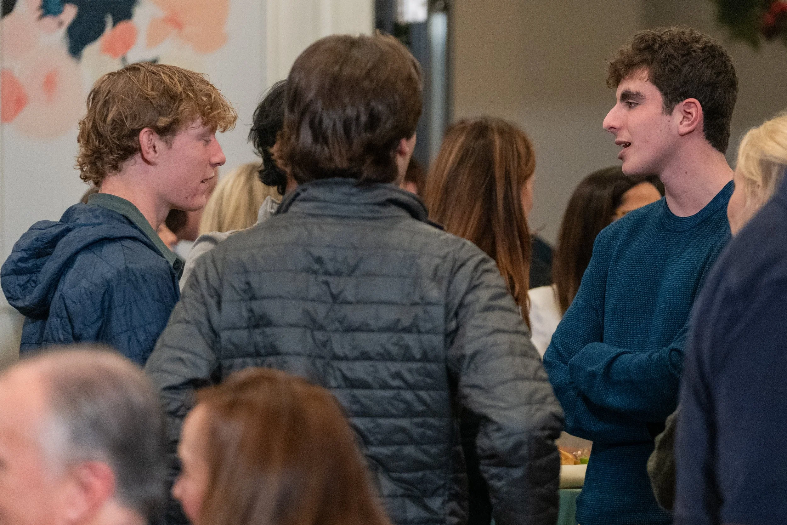 Group of people engaged in conversation at a gathering.