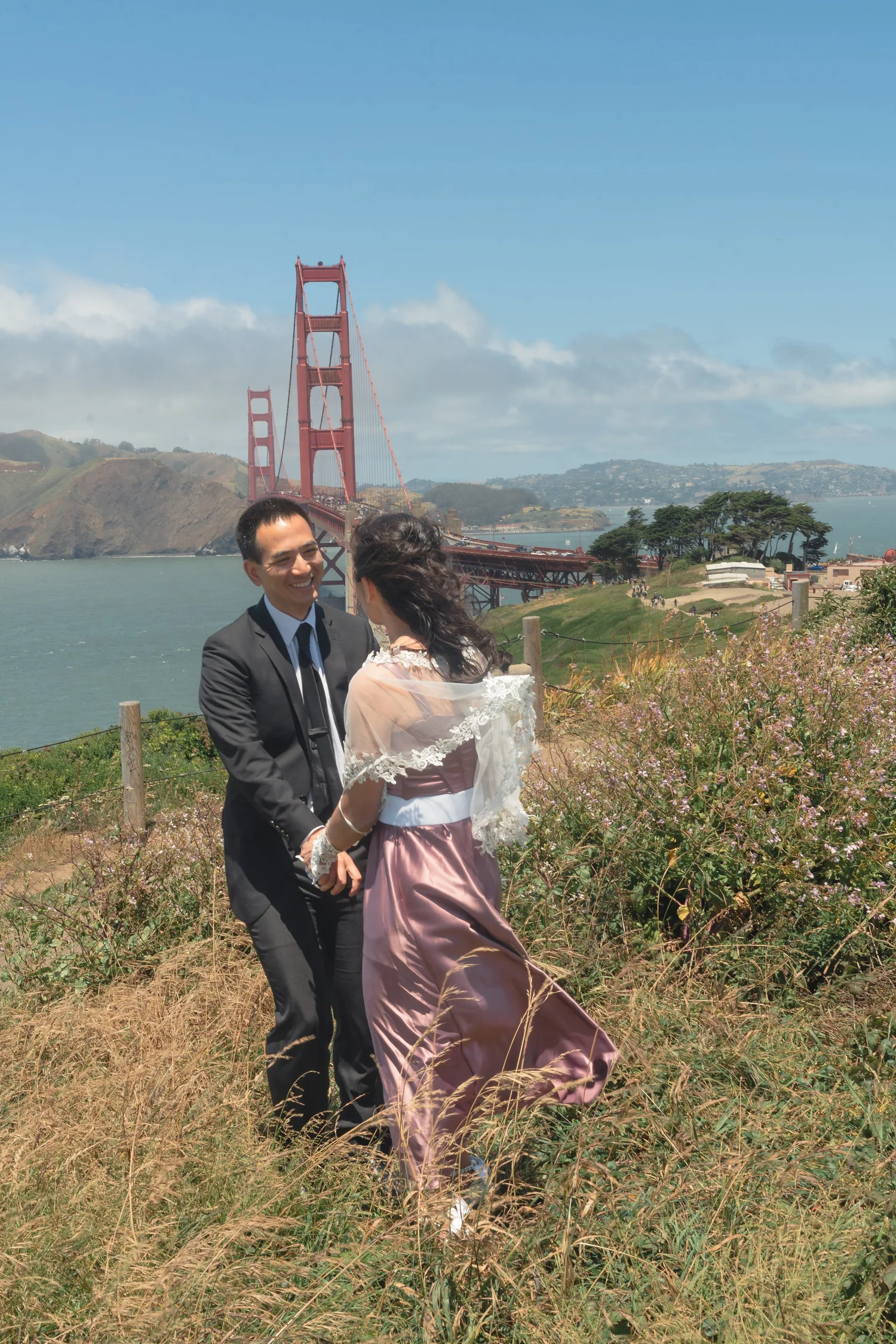 Phorum and Sam walking hand in hand, Golden Gate Bridge behind