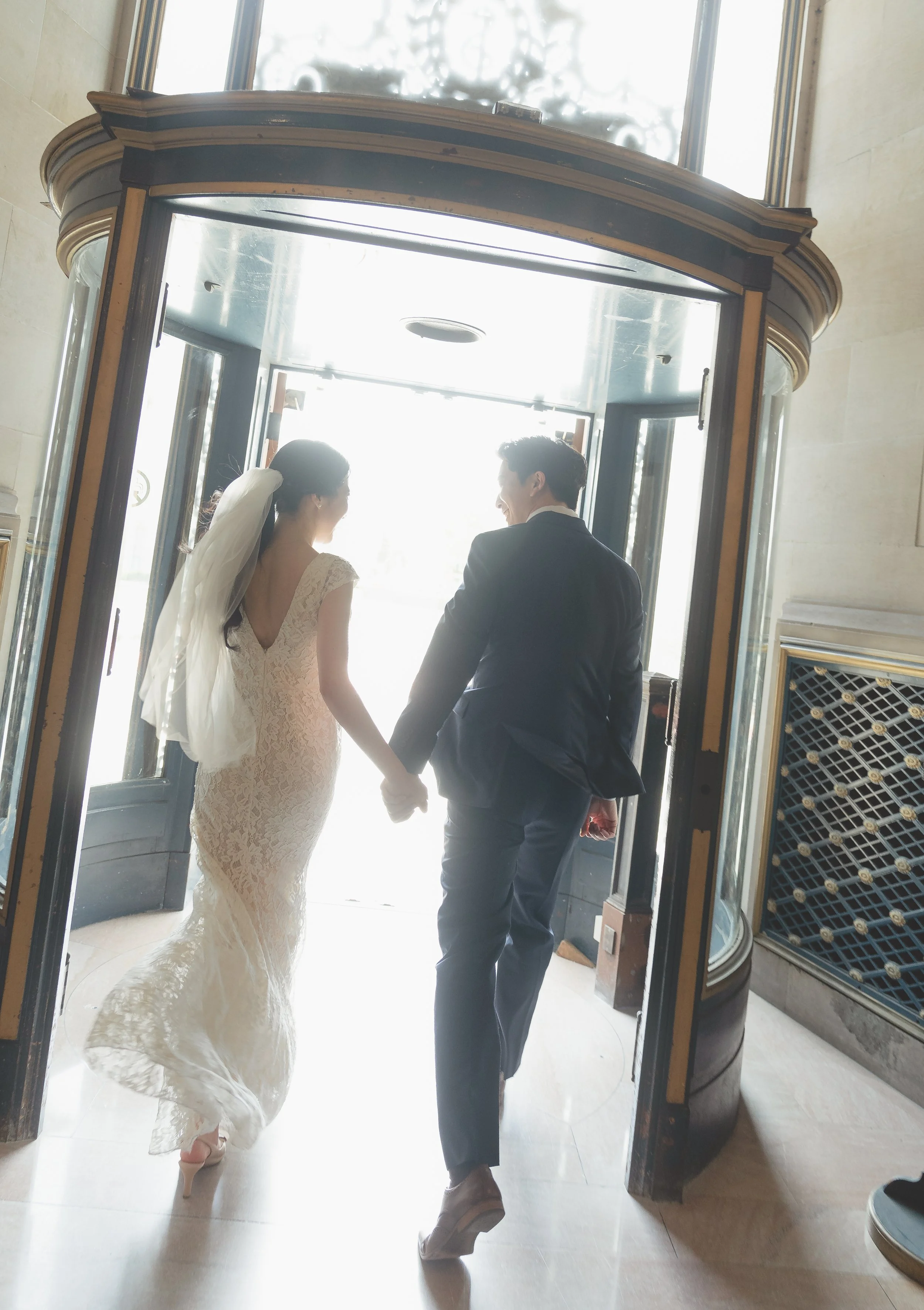 Newly married couple walking out of San Francisco City Hall after their civil ceremony.