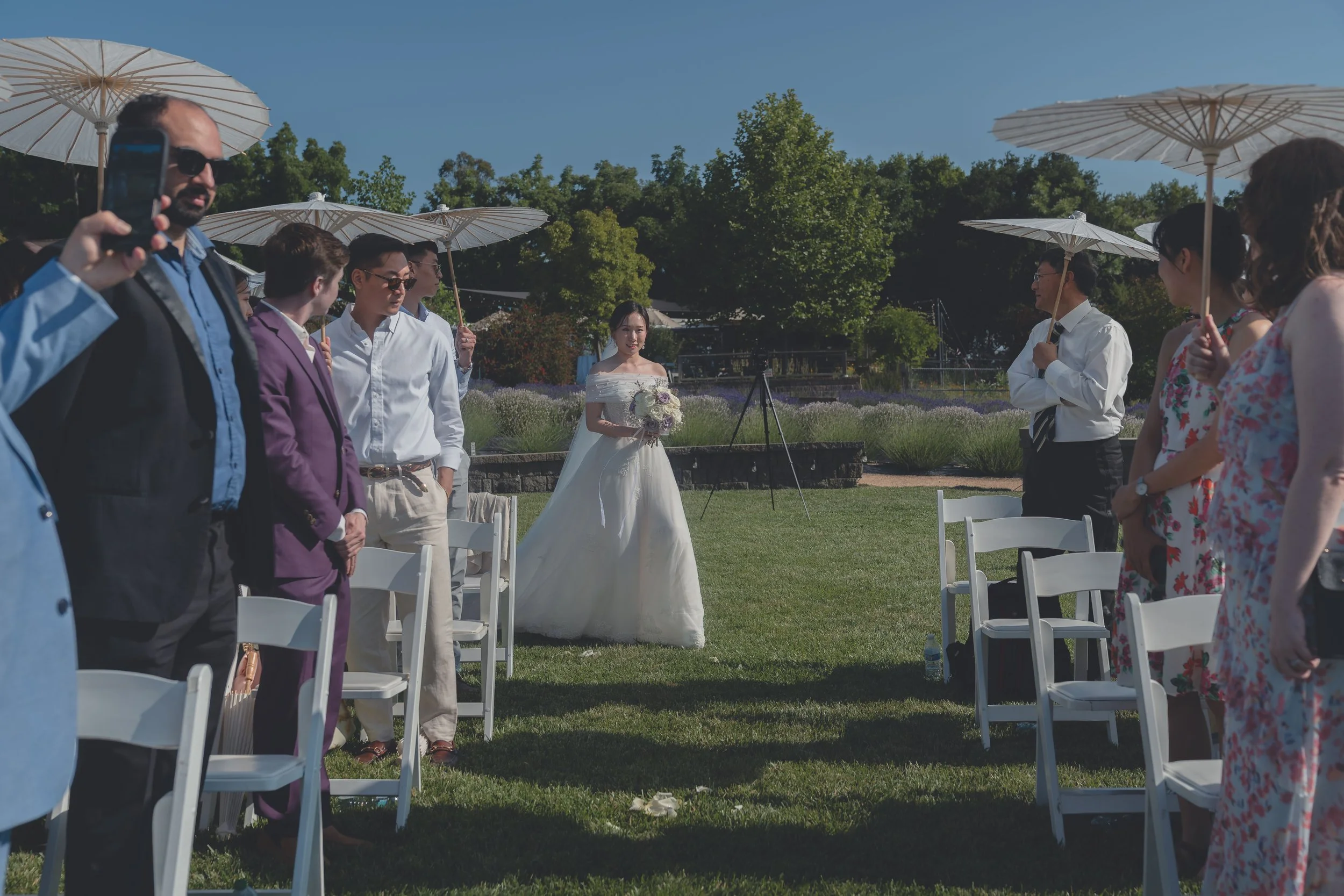 Guests standing as the bride walks down the aisle at a Sonoma wedding.