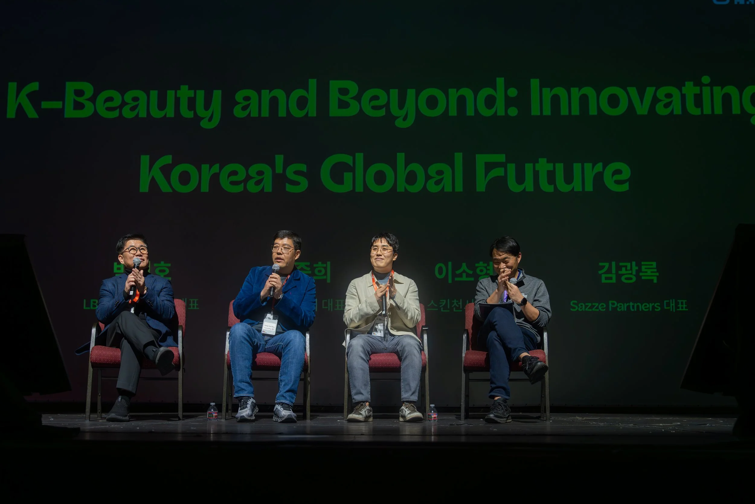Panel discussion titled 'K-Beauty and Beyond: Innovating Korea's Global Future' with four speakers seated on a stage, each holding microphones.