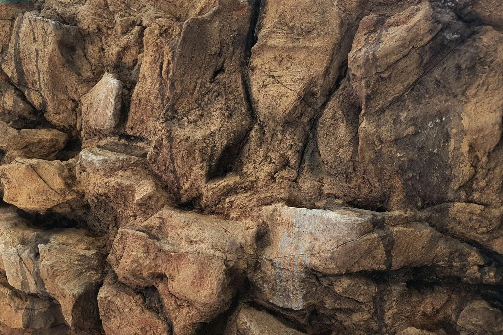 Nahaufnahme einer 3D Rückwand mit verschieden großen, braunen Steinen.