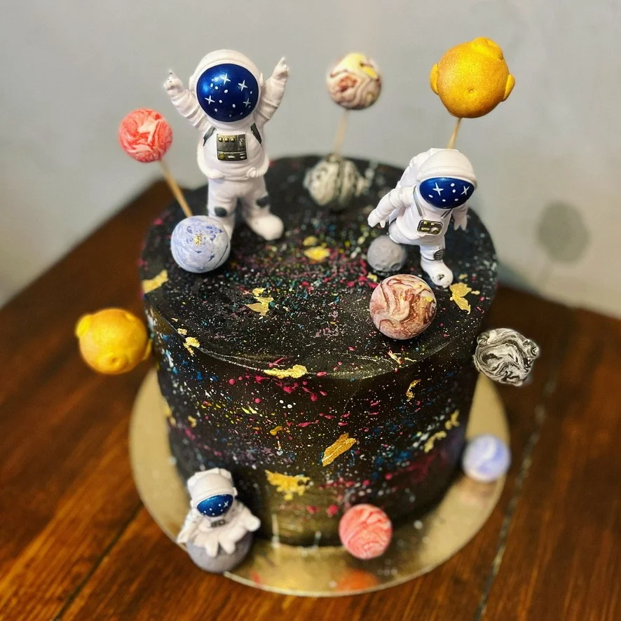 Weltraum-Torte mit Astronauten-Figuren und Planeten, Nahaufnahme