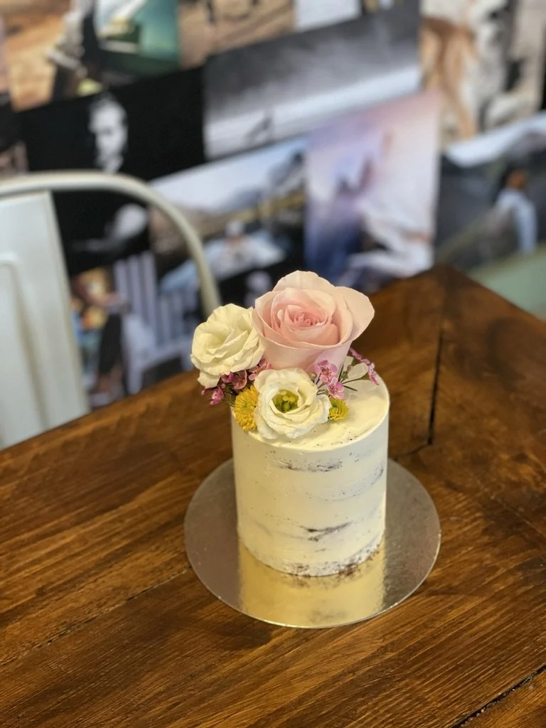 Mini-Torte im Semi-Naked-Look mit Rosen auf einem Holztisch