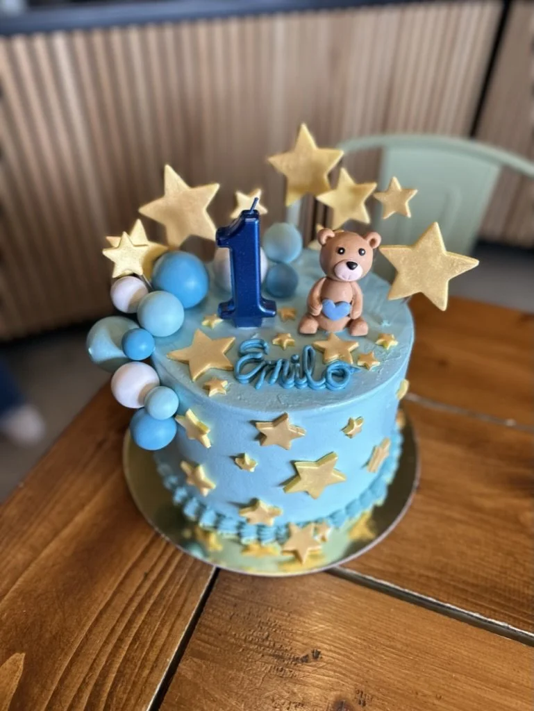 Hellblaue Kindertorte mit goldenen Sternen, Zahl 1 und kleiner Figur