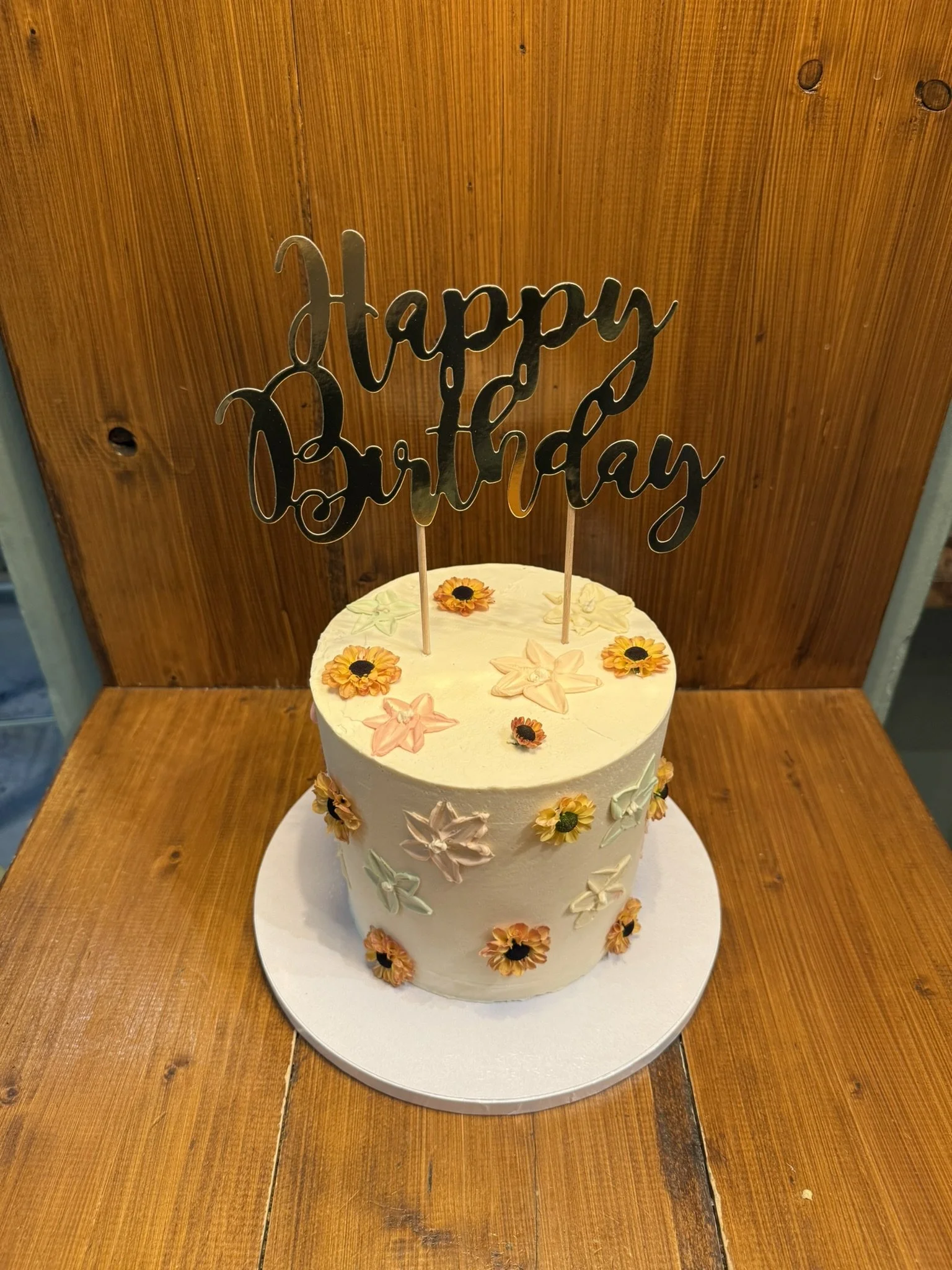 Beige Torte mit kleinen Blüten und Happy-Birthday-Topper