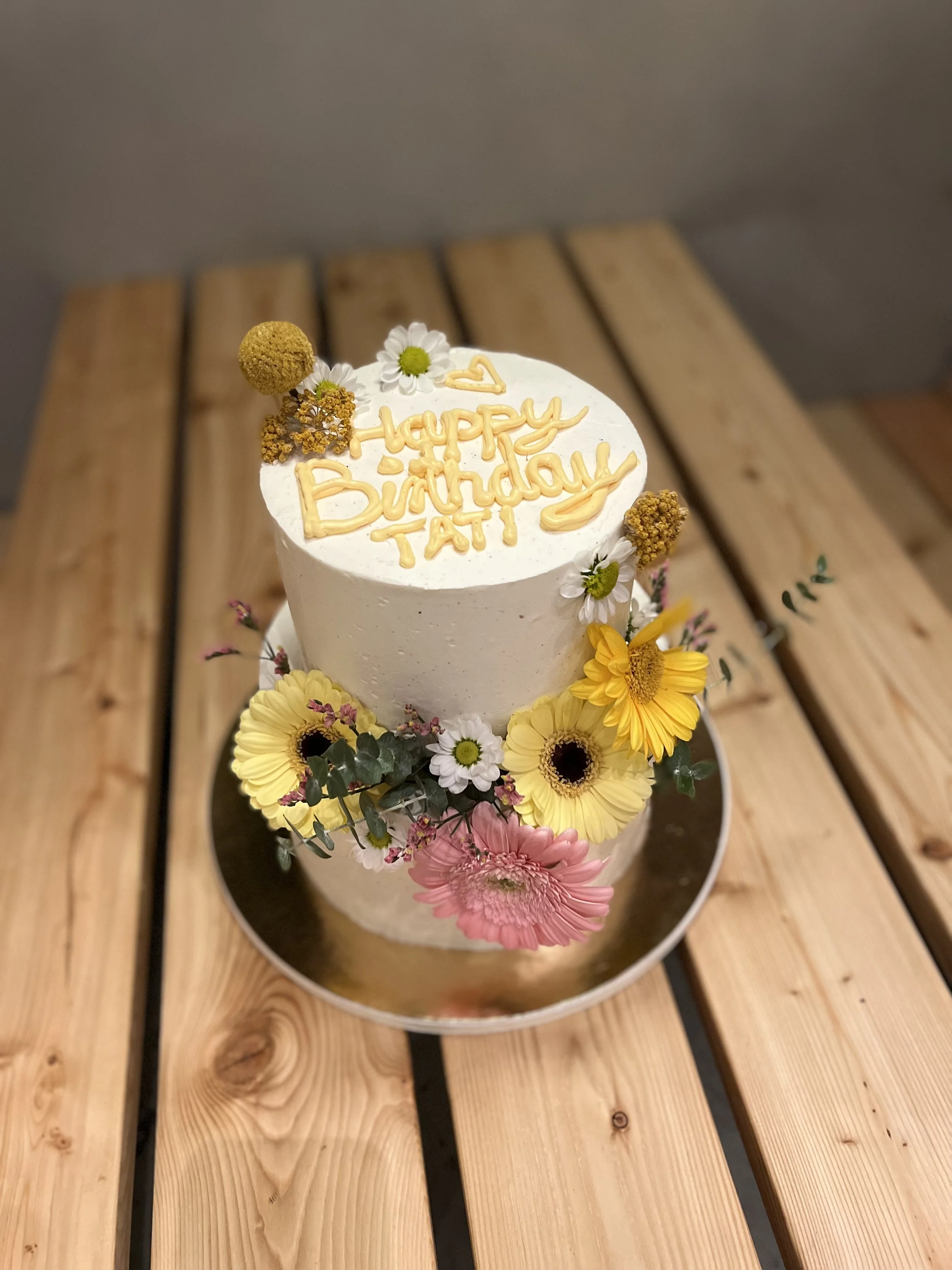 Zweistöckige Torte mit Gerbera, Sonnenblumen und Happy-Birthday-Topper