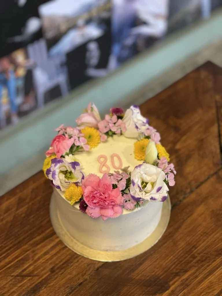 Weiße Torte mit bunten Blumen und Zahl