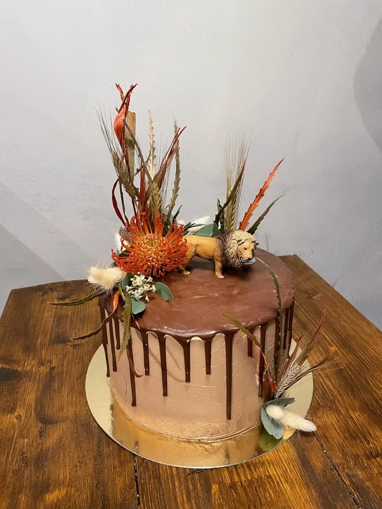 Schoko-Drip-Torte mit Trockenblumen und Tierfigur
