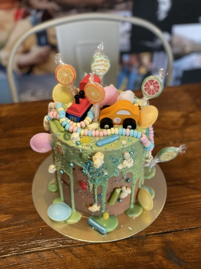 Bunte Drip-Torte mit Lollis, Süßigkeiten und Spielzeugauto