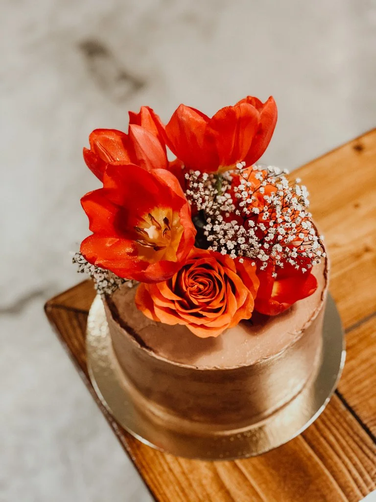 Torte mit orangefarbenen Tulpen und Rosen